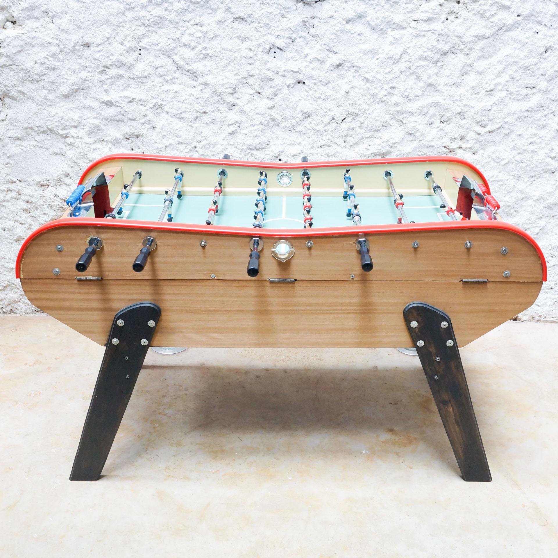 Table football style of Bonzini from France, circa 1990.

In original condition, with minor wear consistent with age and use, preserving a beautiful patina.

Material:
Metal
Wood

Dimensions:
D 110 cm x W 168 cm x H 104 cm.