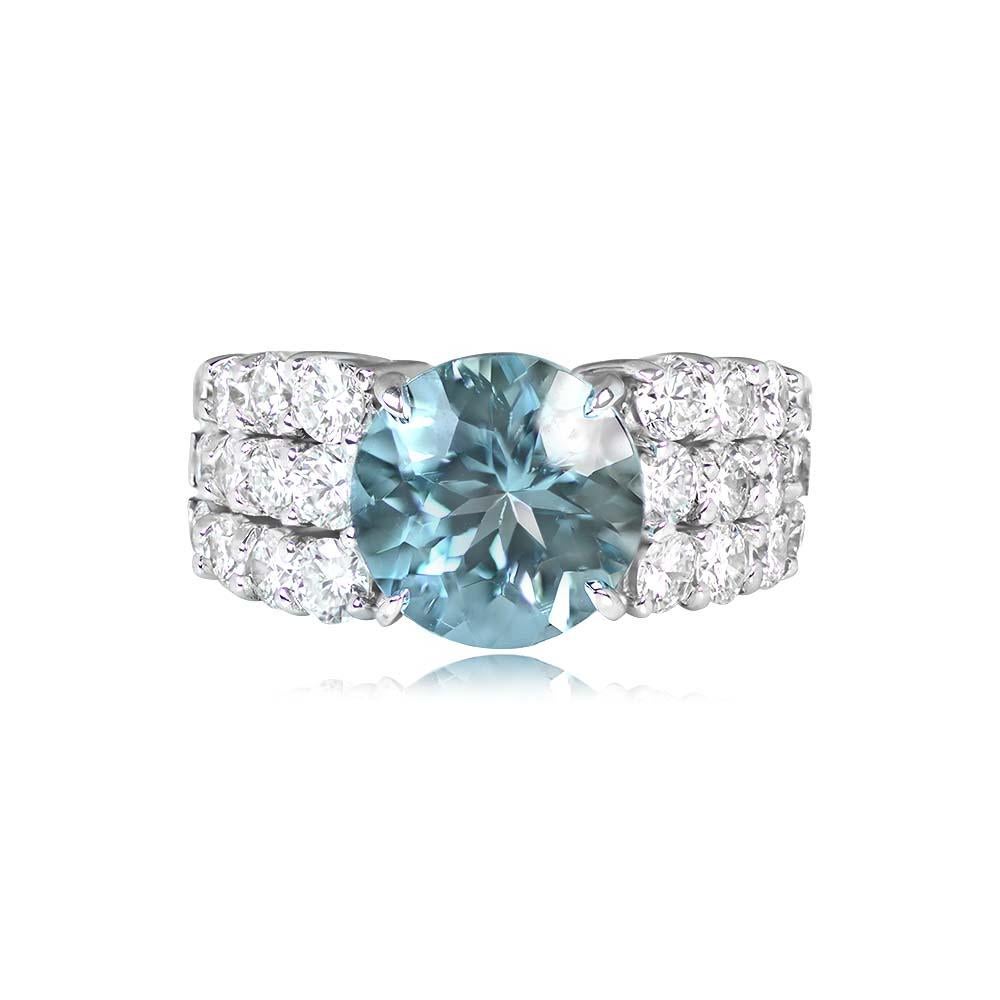 This impressive vintage ring showcases a round-cut 3.71-carat aquamarine center, prong-set, and surrounded by three rows of four round brilliant cut diamonds on each side. The diamonds have an H color and VS1-VS2 overall quality, with a total