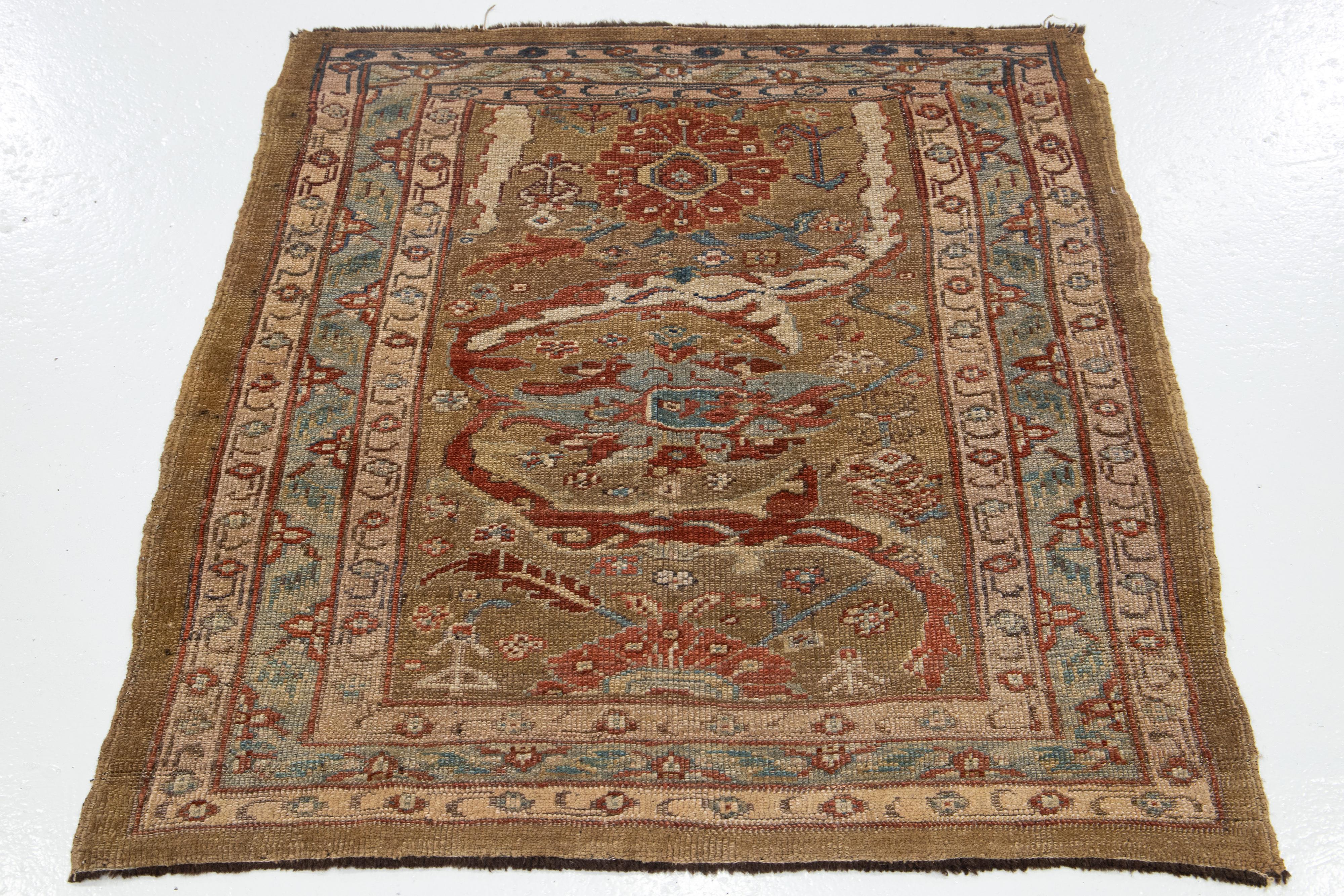 Dieser handgeknüpfte, quadratische Teppich aus persischer Wolle von Bakshaeish gehört zu unserer Revival Collection'S. Es zeigt ein auffälliges braunes Feld, das durch mehrfarbige Akzente ergänzt wird, die in ein faszinierendes florales
