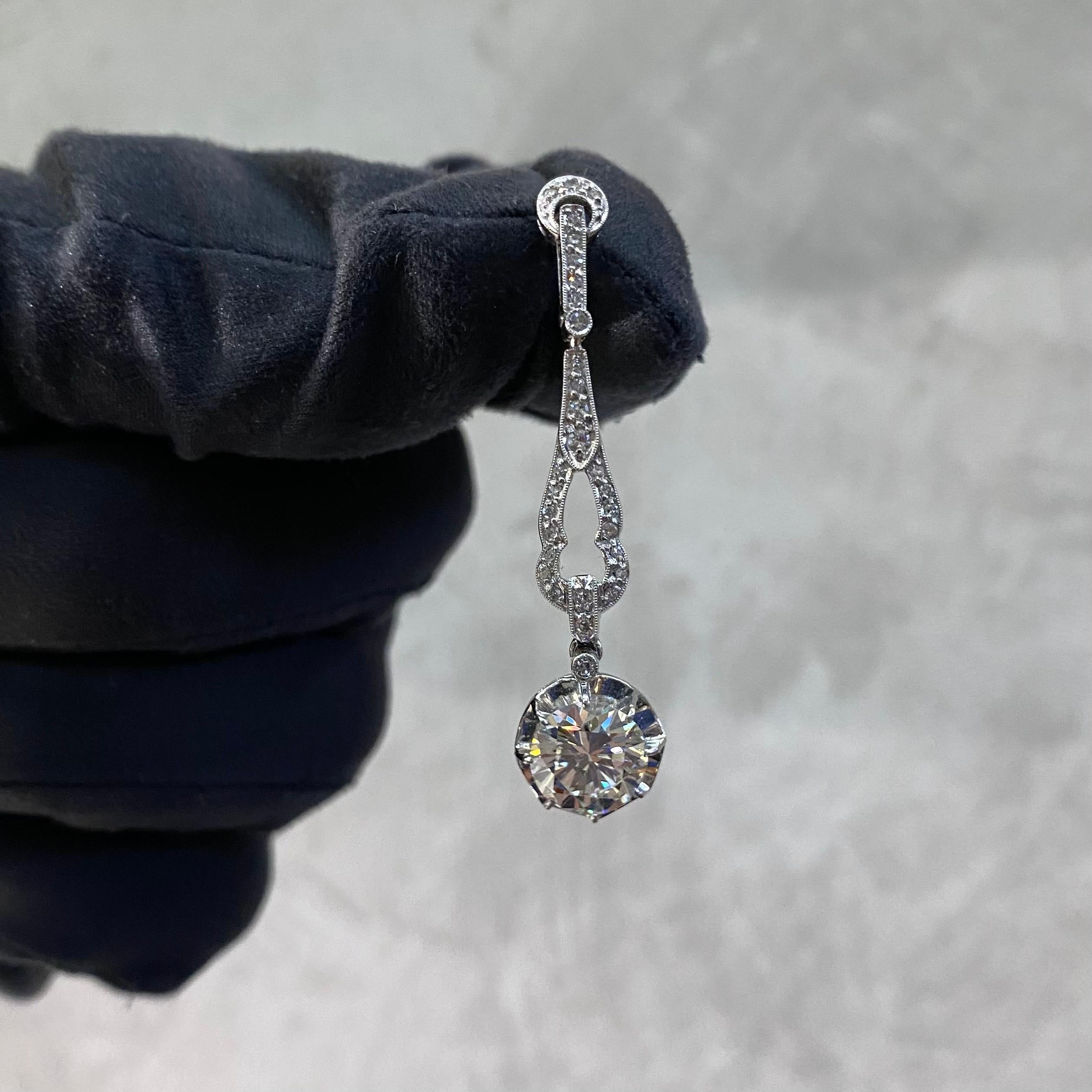A pair of vintage diamond pendant drop earrings in 18kt white gold, vintage from the 1990s. Designed in the Art Deco style, each earring is composed by a crescent Moon and geometric surmount millegrain-set throughout with single-cut diamonds and it