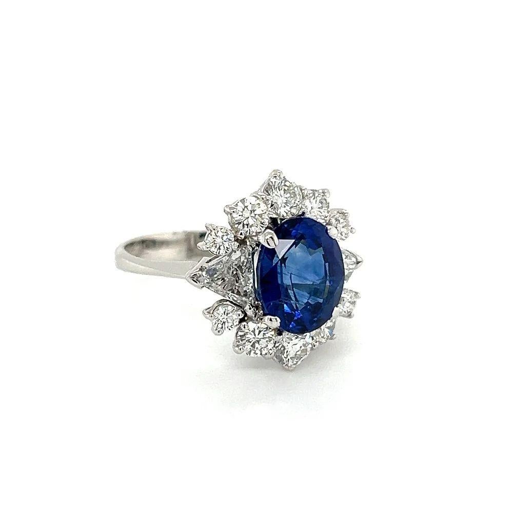 Simply Beautiful! Finely detailed GRS Vivid Blue Sapphire and Diamond Vintage Gold Cocktail Ring. Centering a securely nestled Hand set 5.94 Oval Carat GRS Vivid Blue Sapphire surrounded by Trillion and Round Diamonds, weighing approx. 2.03tcw. Hand
