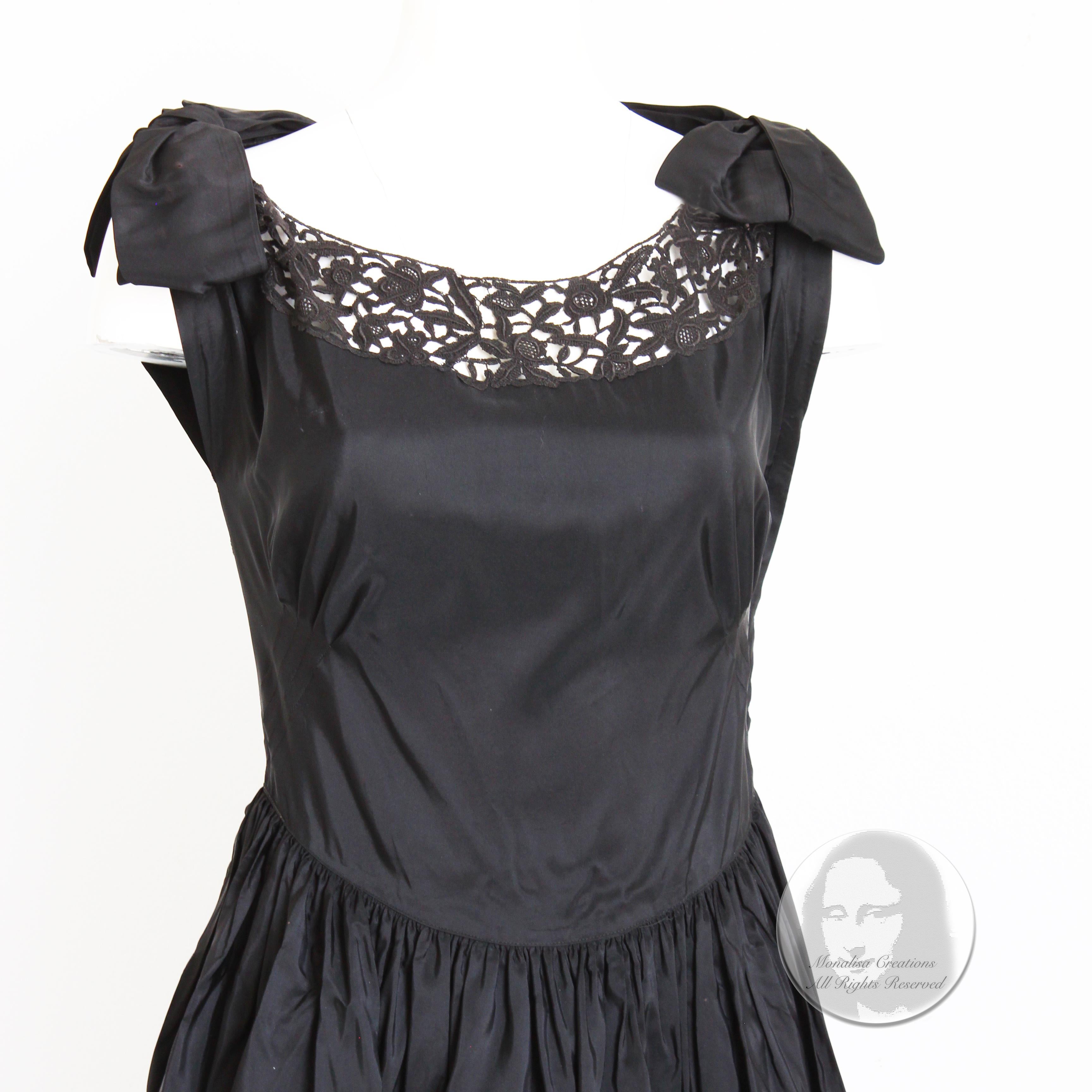 Fabuleuse robe de soirée vintage, probablement fabriquée à la fin des années 40 ou au début des années 50. Confectionnée en taffetas noir, elle présente un ourlet en dentelle festonnée noire et des empiècements en dentelle sur la poitrine et dans le