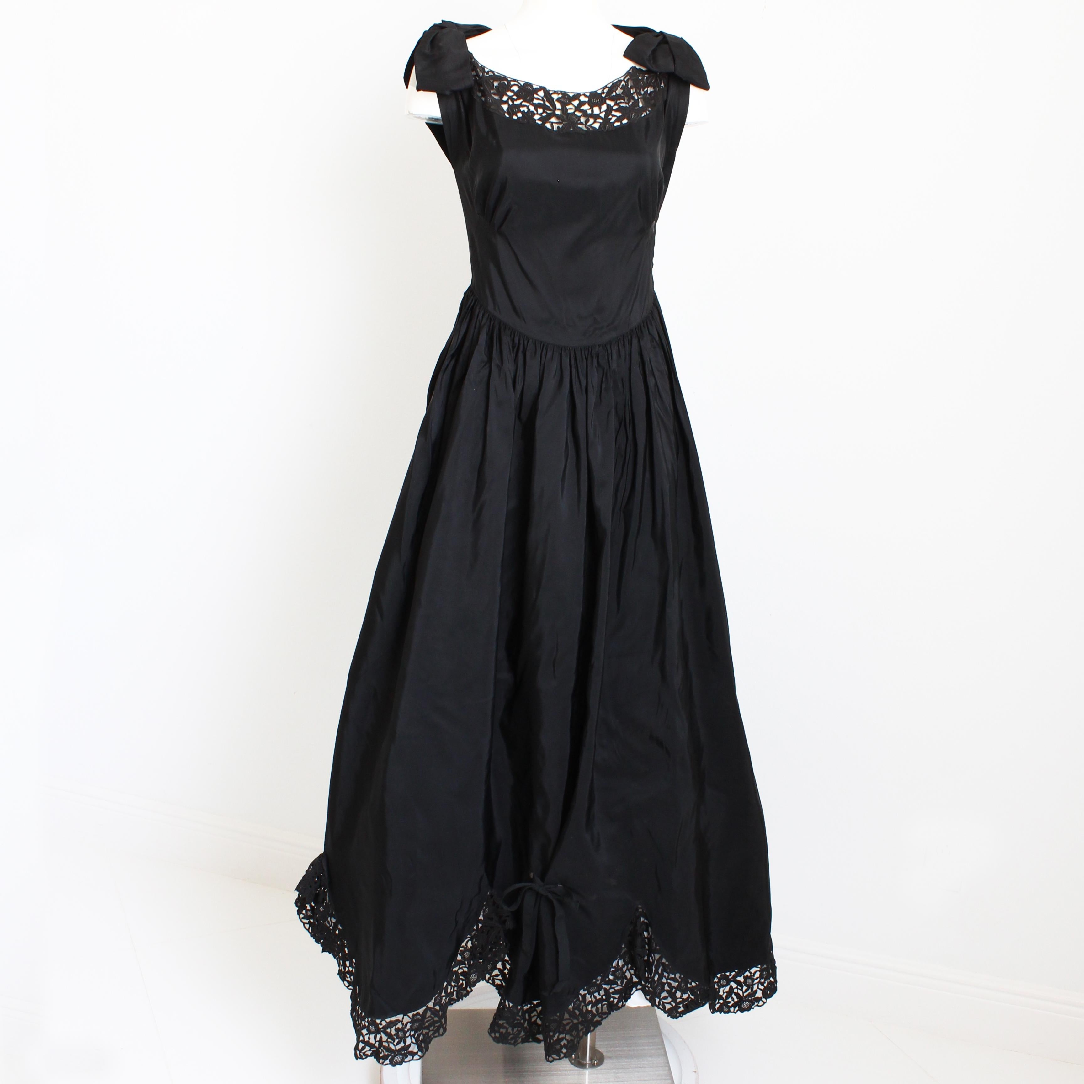 Fabulous vintage evening dress or gown, likely made in the late 40s or early 50s. Made from black taffeta, it features a black scalloped lace hem with lace inserts at the chest and back - so chic! It's got darts at the bodice , a gathered dropped
