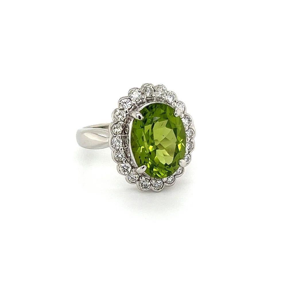 Simply Beautiful! Finely detailed Vintage Solitaire Oval Peridot and Diamond Platinum Ring. Centering a securely nestled Hand set 4.19 Carat Oval Peridot, surrounded by Bezel set Diamonds, weighing approx. 0.50 total carat weight. Beautifully Hand