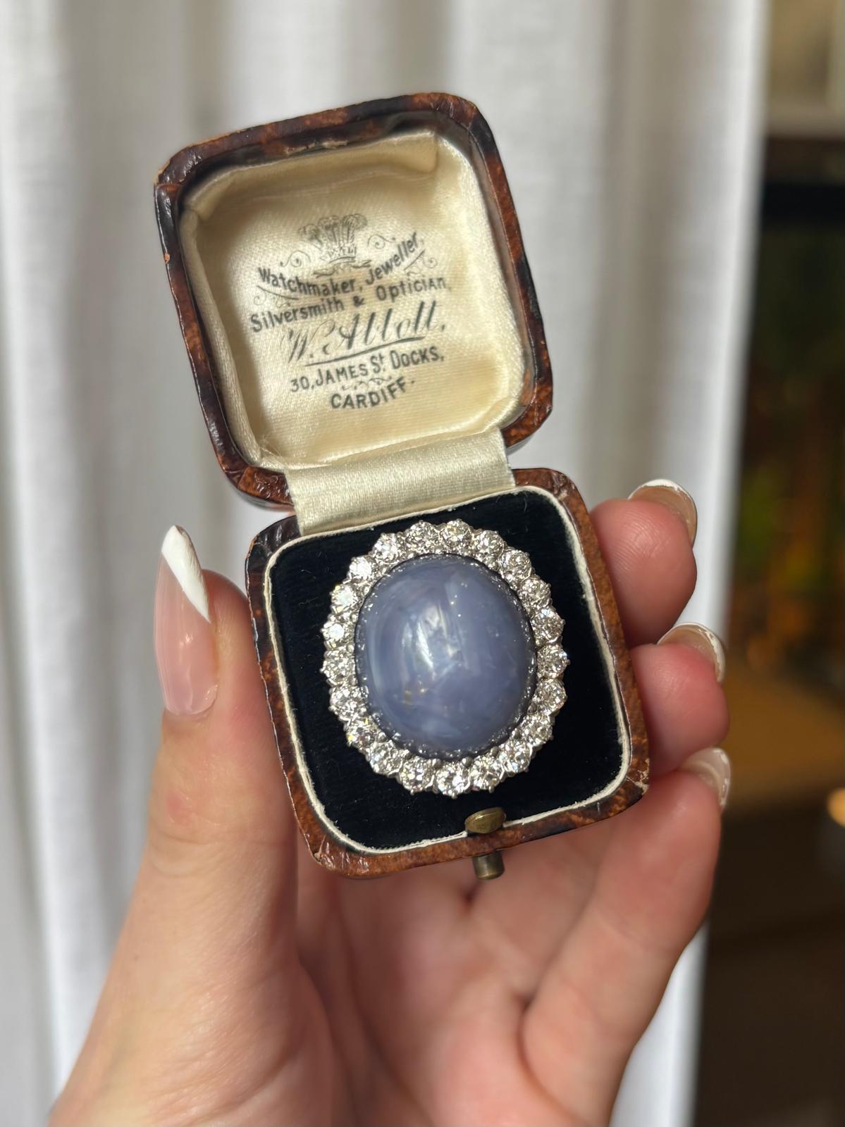 An impressive vintage star sapphire and old cut diamond cluster cocktail ring set in 18k gold.

The piece is predominately set with a large oval cabochon star sapphire which is securely claw set. The star sapphire is set amongst a cluster of old cut