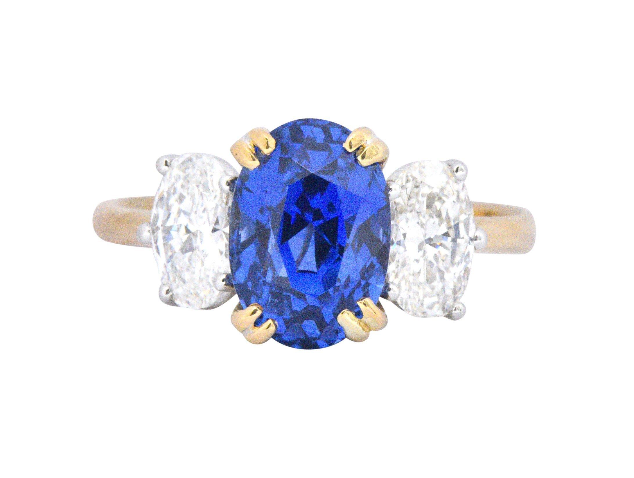 Centering a stunningly royal blue oval cut Madagascar sapphire, with no evidence of heat, weighing 3.22 carats

Flanked by two oval cut diamonds weighing approximately 1.00 carat total, G color with VS clarity

Classic three stone ring with trellis