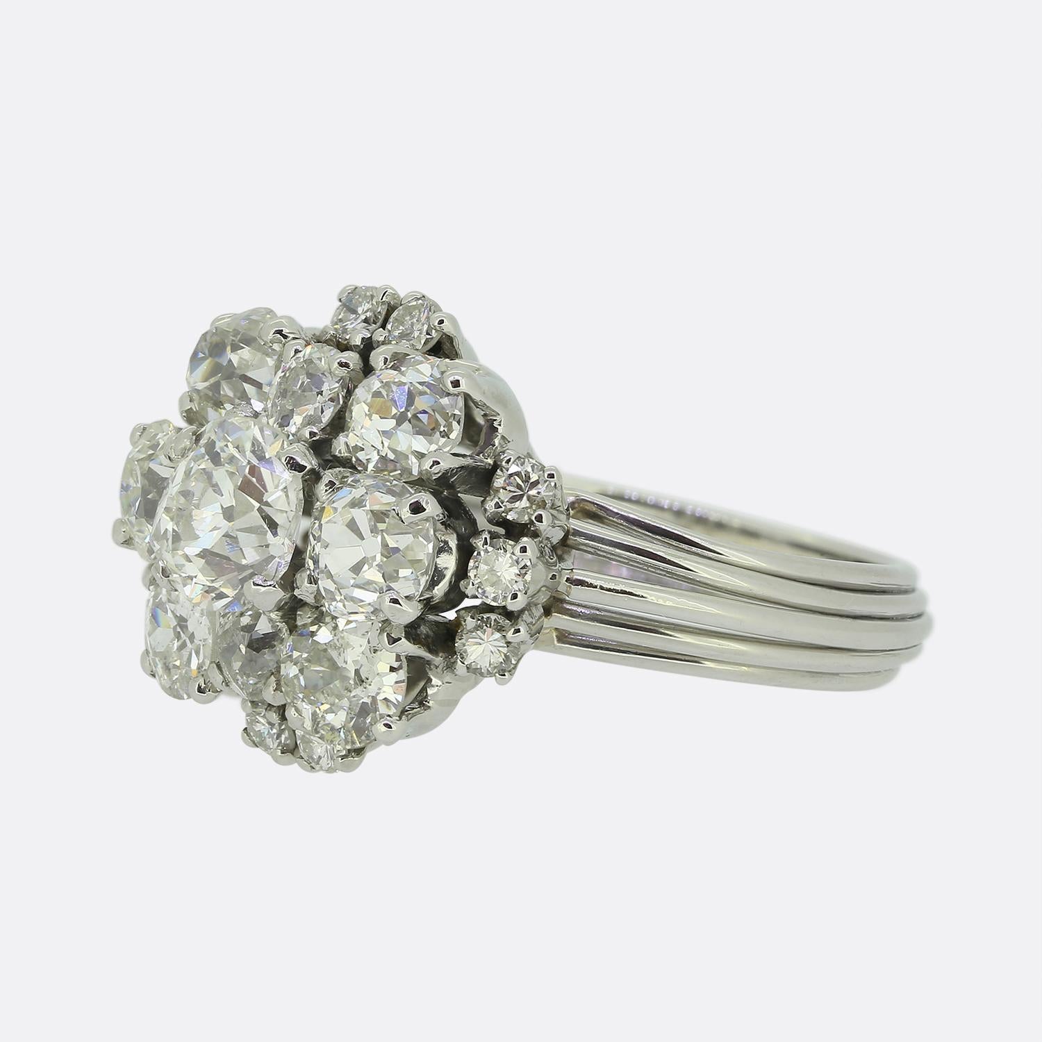 Here we have a truly beautiful old cut diamond ring dating back to the mid 20th century. The ring features a raised central old cut diamond that weighs approximately 1.0 carat and is surrounded by 18 slightly smaller old cuts. In total it plays host