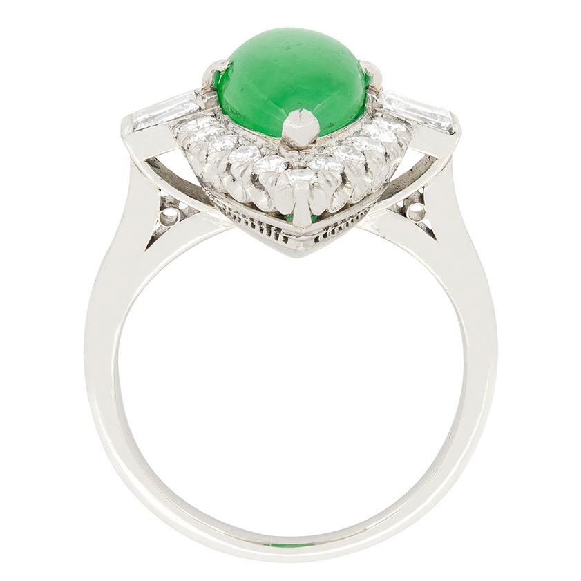 A show stopping, 4.50 carat Jade is surrounded by a halo of round brilliant diamonds in this vintage cocktail ring. The marquise cabochon cut Jade is a completely natural and unenhanced stone certified by GIA. The surrounding Halo of diamonds old