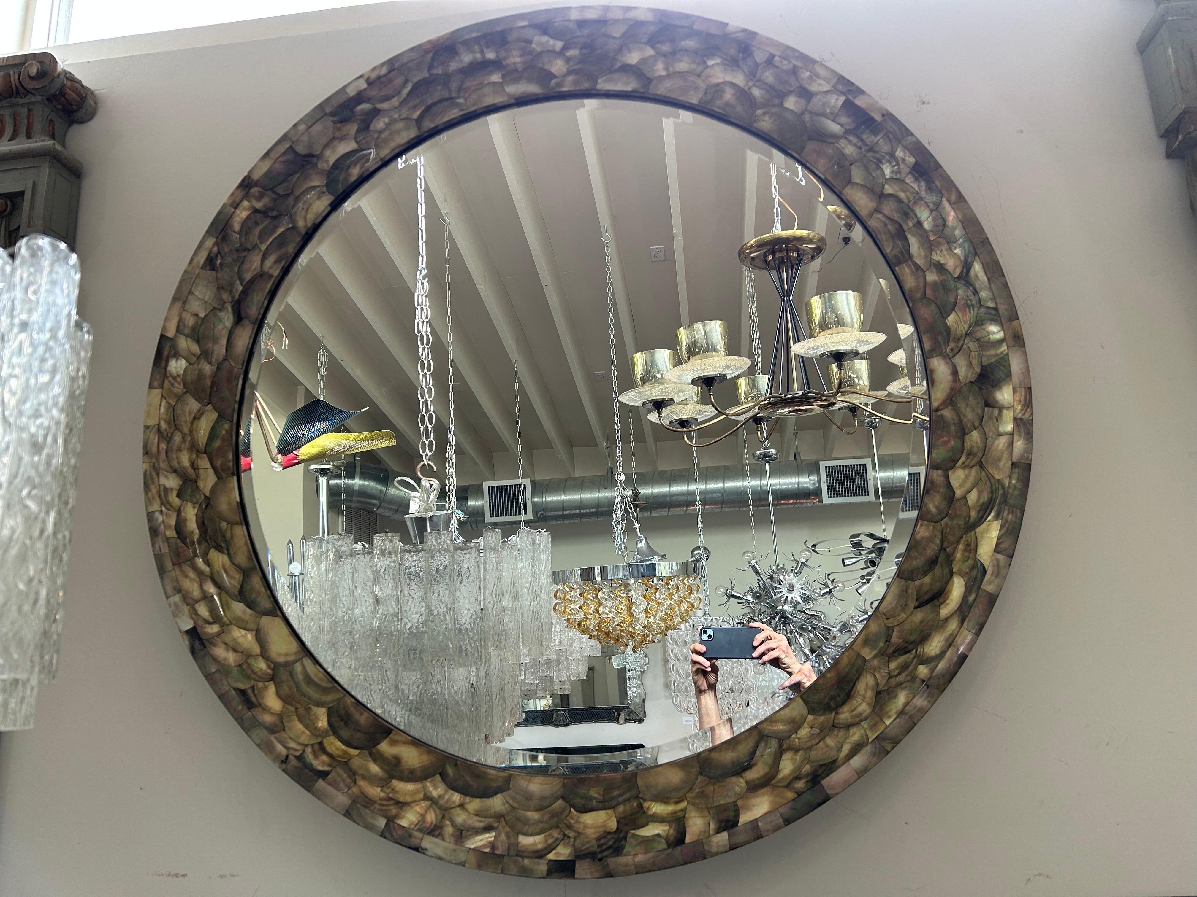 Vintage 47 Inch Round Abalone Beveled Mirror.
This stunning monumental Karl Springer style round beveled mirror is expertly crafted with artistically placed pieces of abalone including the exterior.
Our versatile mirror would look grand in an
