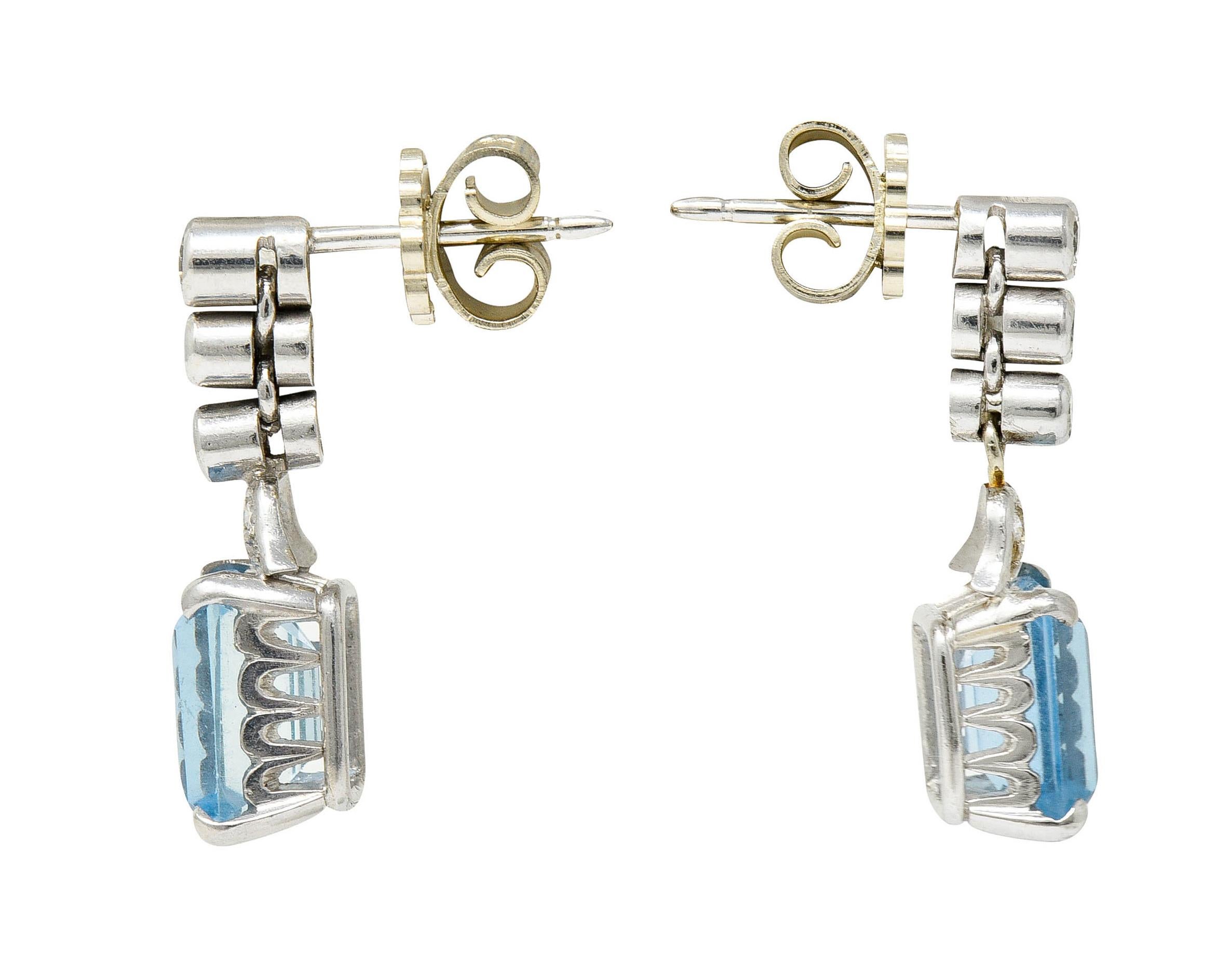 Drop earrings have stylized foliate surmounts comprised of articulated circular links

Accented by round brilliant cut diamonds weighing in total approximately 0.45 carat - G to J color with SI clarity

Features emerald cut aquamarines weighing in