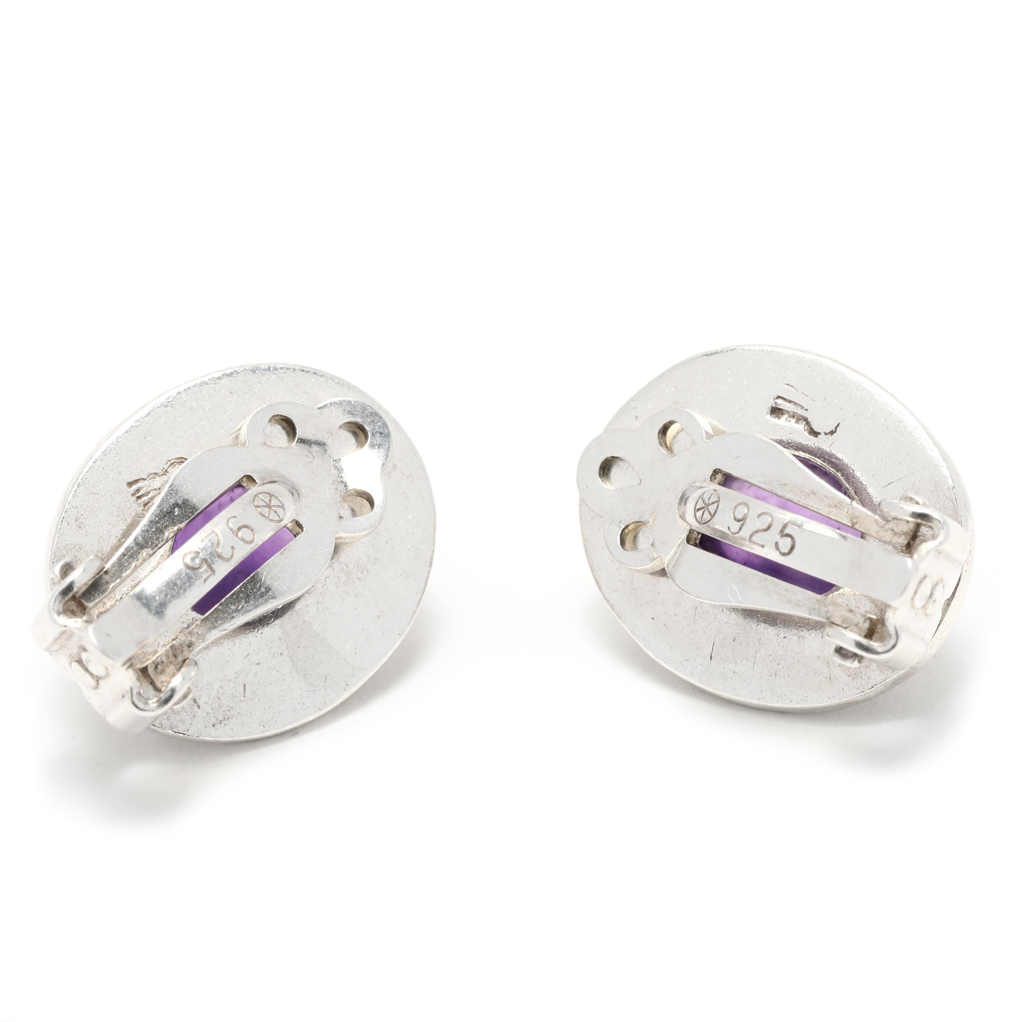 These beautiful vintage 4ctw oval amethyst clip on earrings are a stunning addition to any jewelry collection. Crafted in sterling silver, each earring measures 3/4 inch in length and is engraved with a unique design. The classic oval shape of the