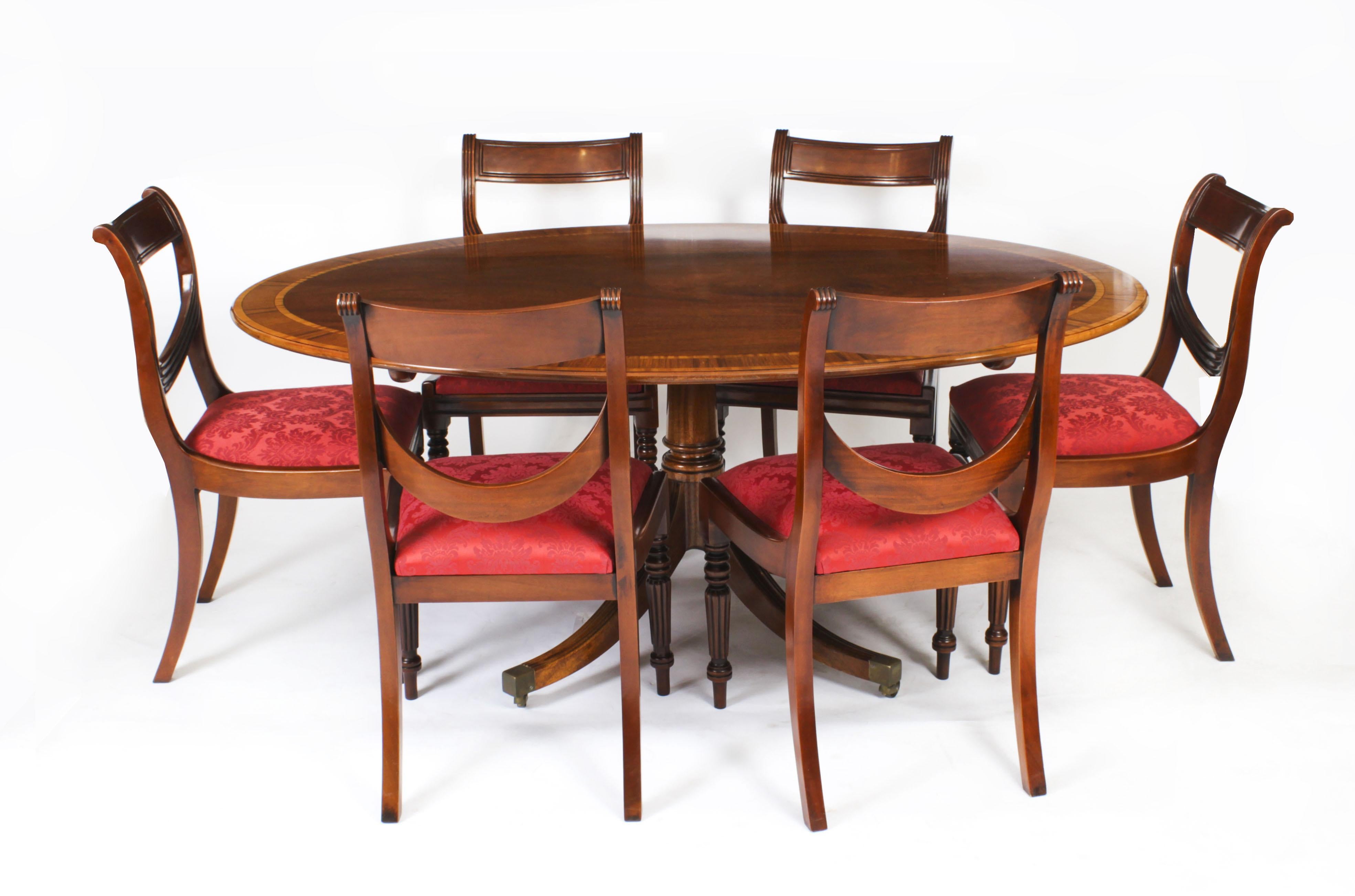 This is a beautiful Regency Revival flame mahogany and Satinwood banded oval dining table dating from Circa 1980 that was made by the Master Cabinet maker William Tillman and bears his label on the underside. 

The fabulous 5ft 6inch flame