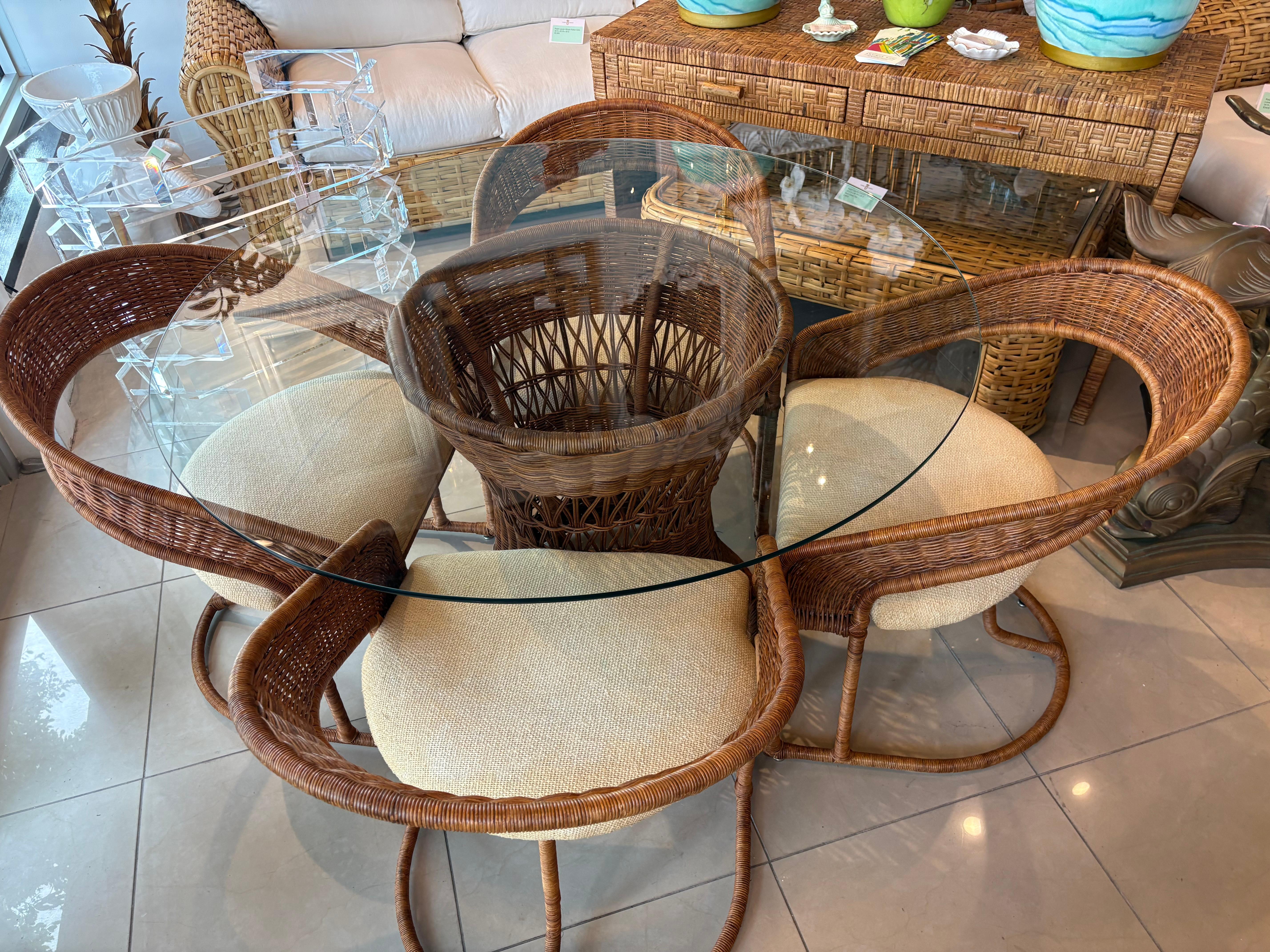 Set da pranzo da 5 pezzi in vimini e rattan. Include 4 sedie a sbalzo, 1 base da pranzo e piano in vetro. La base del tavolo in vimini presenta 2 aree leggermente danneggiate, come da foto. I cuscini delle sedie sono originali e dovranno essere