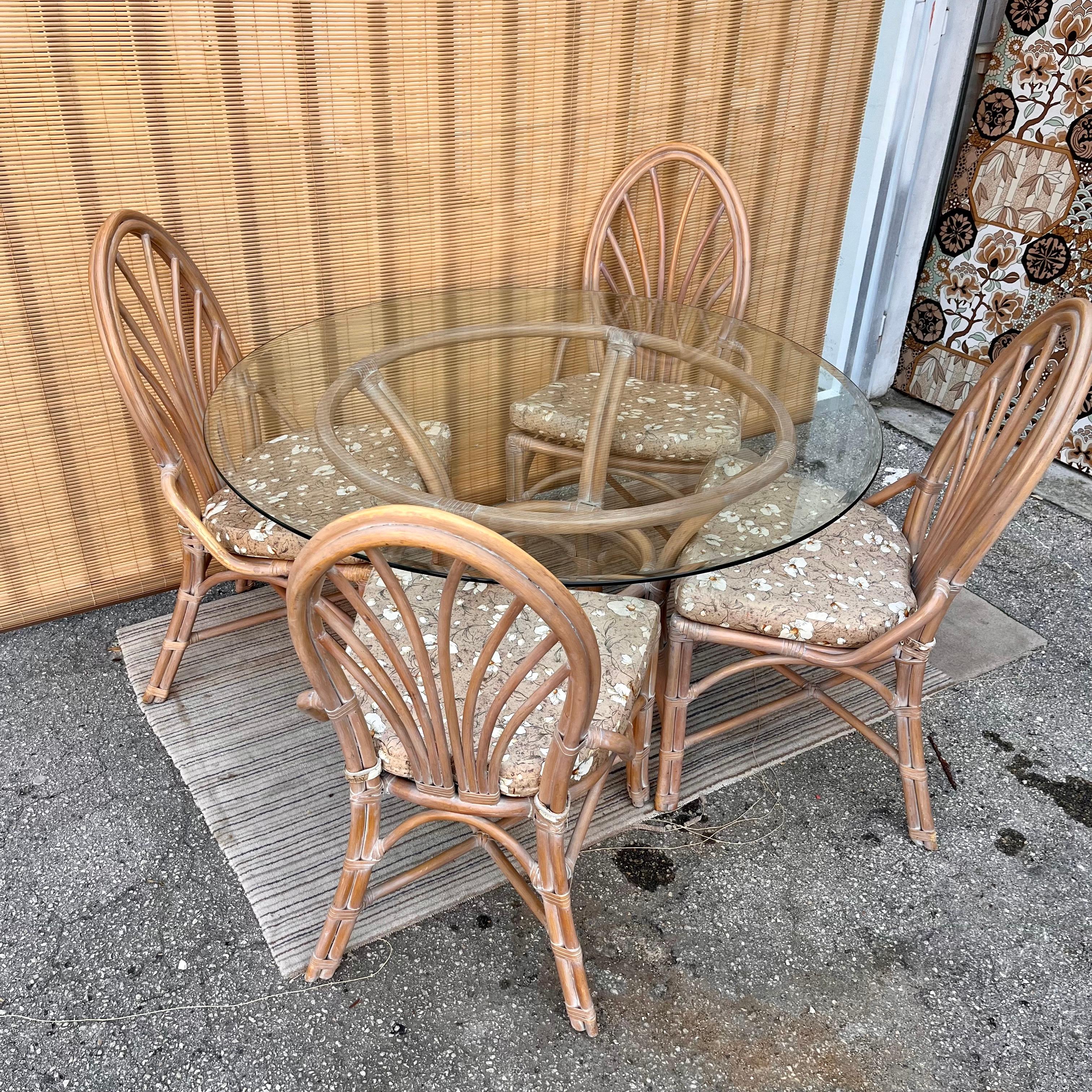 Vintage 5 Pieces Coastal Style Rattan dining set in the McGuire's Manner. Circa 1980s 
Features an intricate bent rattan fretwork in an antique washed white finish bounded by laced rawhide to complement the design. The chairs come with removable