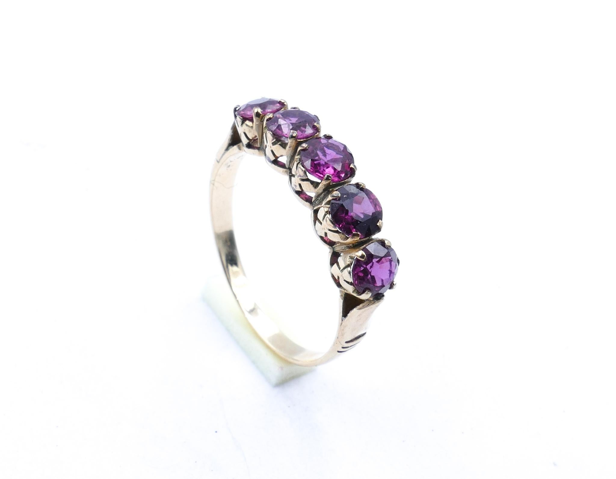 This is a great buy! 

A really unusual colour for a Ruby, being toward the reddish purple instead of the reddish pink it is comprised of 5 evenly matched stones set in 9ct Yellow Gold.

The Design is such that it sits beautifully across the finger