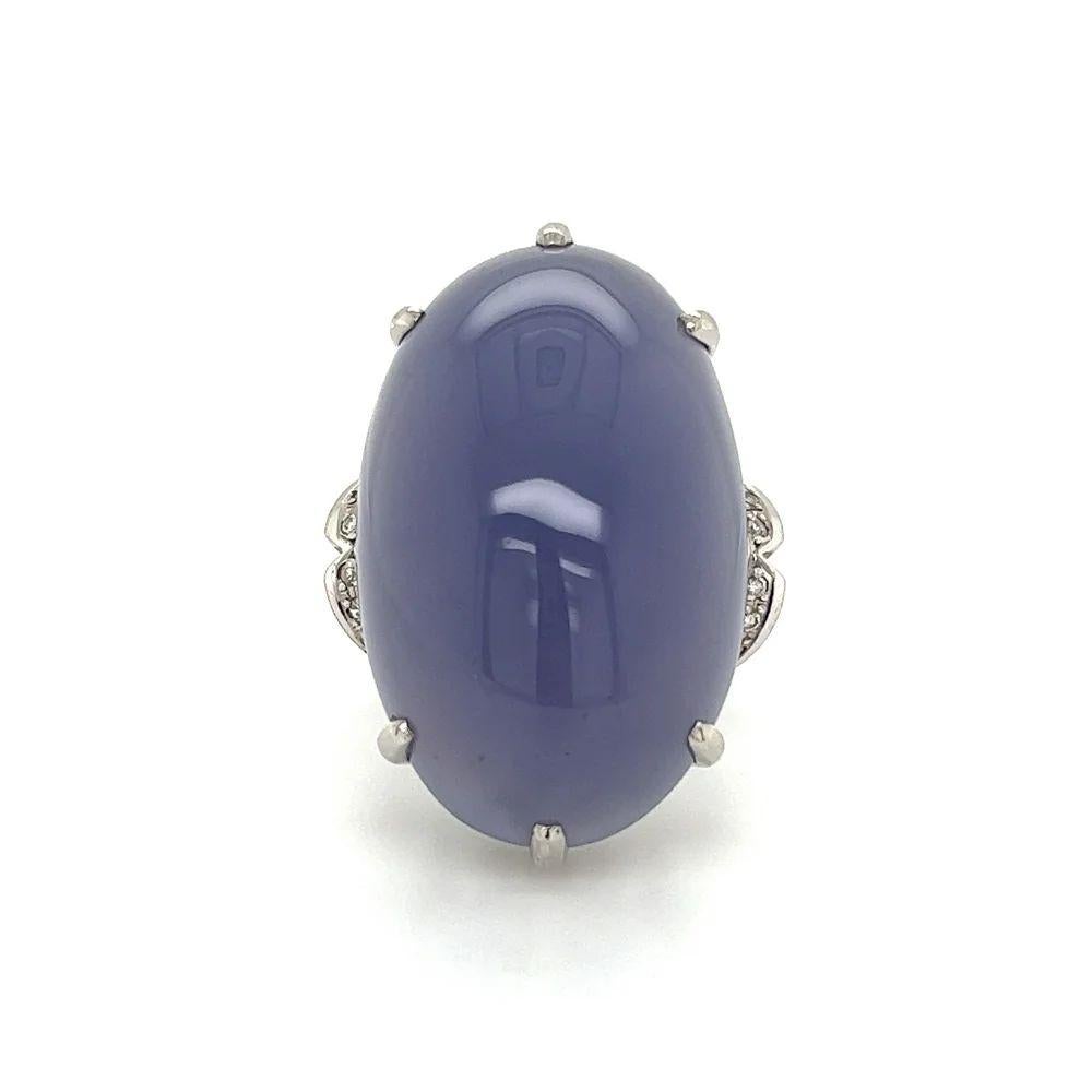 Simply Beautiful! Finely detailed Oval Blue Chalcedony Gemstone and Diamond Platinum Solitaire Cocktail Ring. Centering a securely nestled 50 Carat Cabochon Oval Blue Chalcedony accented either side with Diamonds, weighing approx. 0.12tcw. Hand