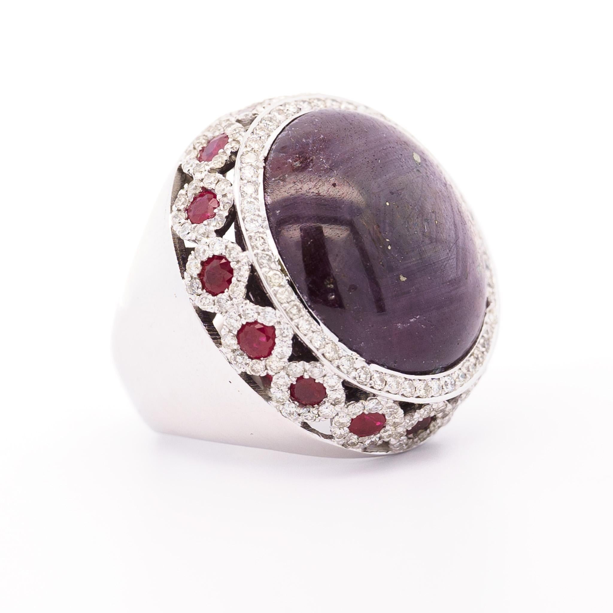 Jewelry Details:
- Item Type: Ring
- Metal Type: 18K White Gold
- Weight: 31 grams
- Size: 8

Center Stone Details:
- Gemstone Type: Star Ruby
- Carat: 50 Carats (approx.)
- Cut: Cabochon-Cut
- Size: 21.5mm 

Side Stone Details:
- Gemstone Type: