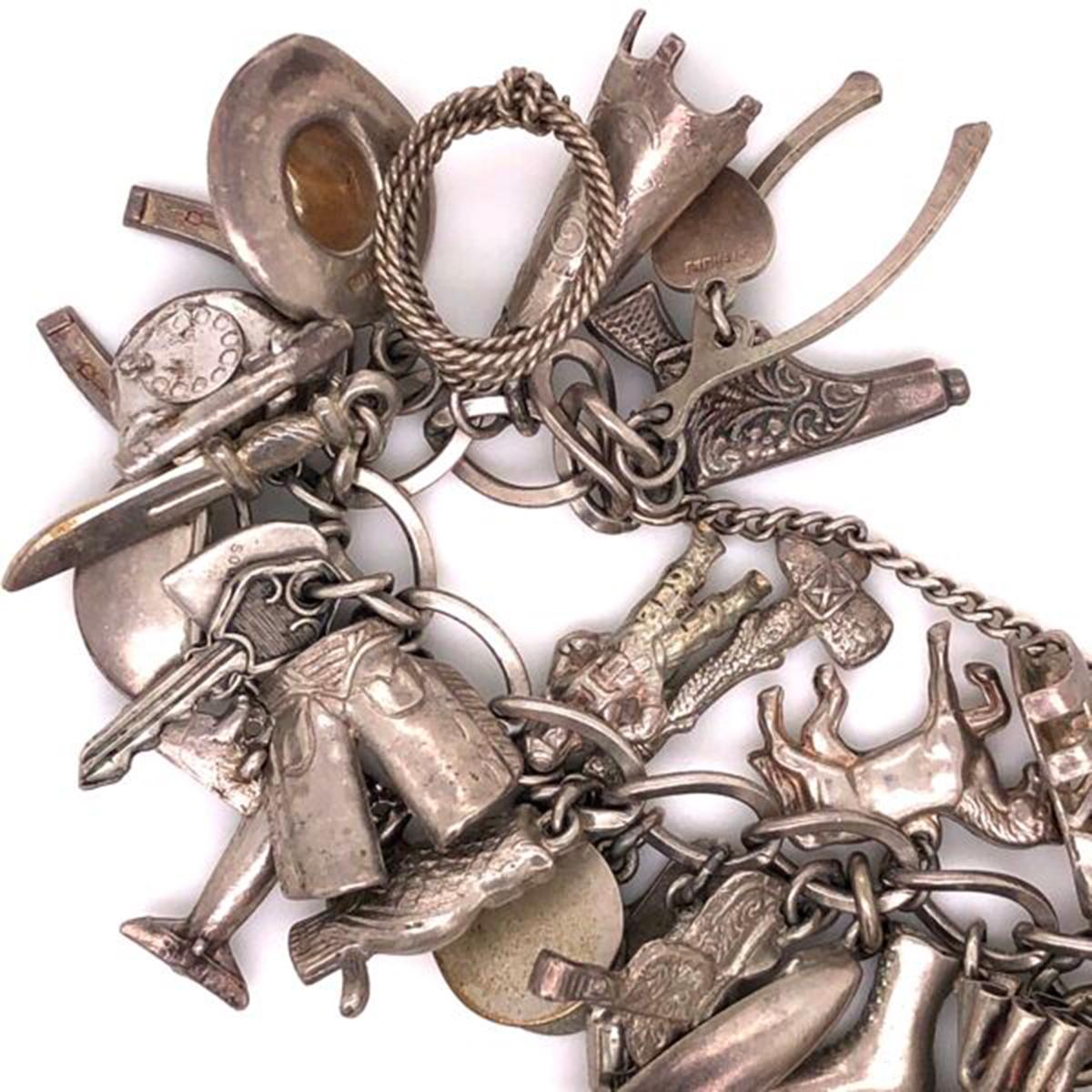 Fabulous 50 Piece Sterling Silver Charm Bracelet; approx. 7.5 inches long; Circa: 1970s. The bracelet is in excellent condition. A perfect complement to your outfit; to enjoy, truly a great conversation piece! Wow Power!
