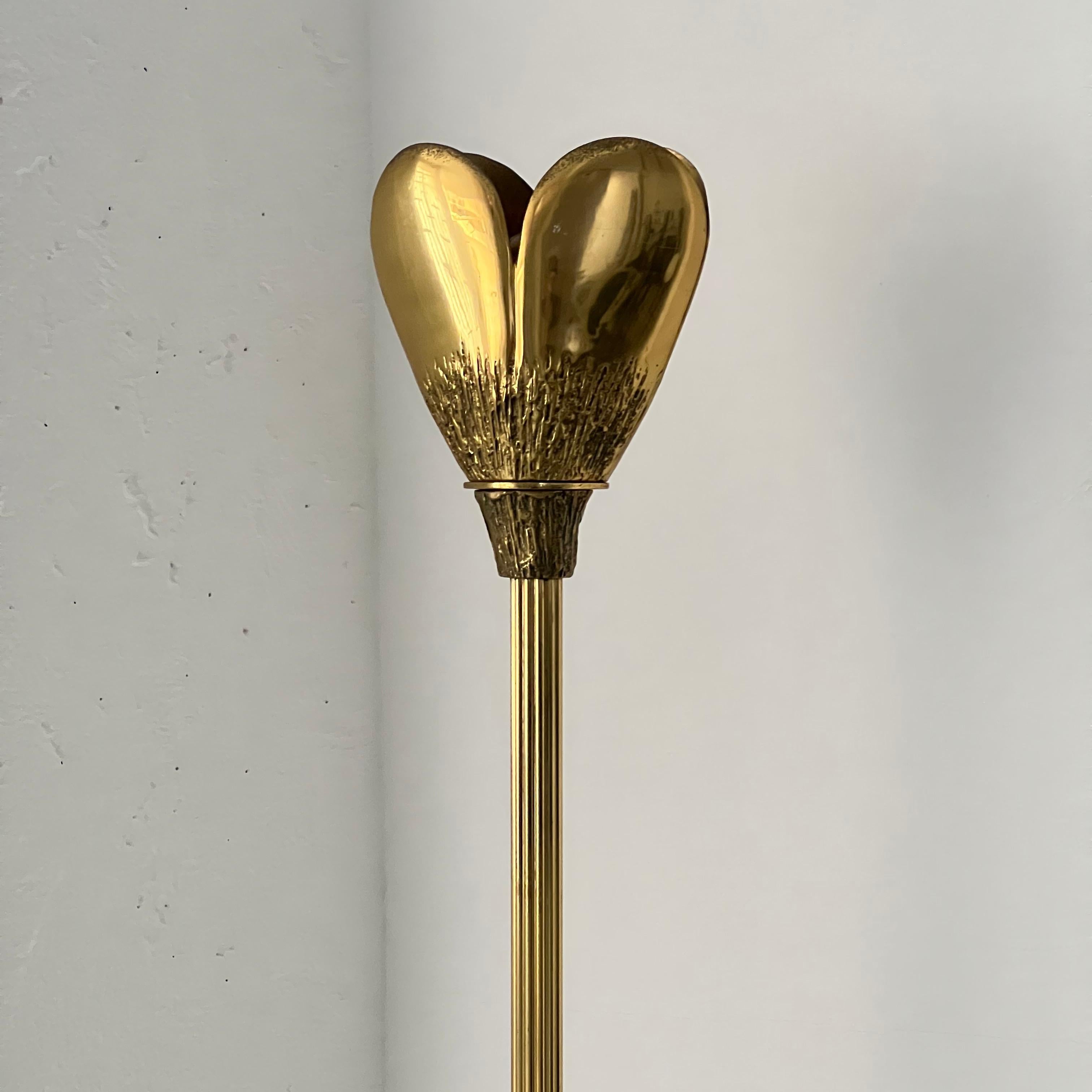 Offered for sale is a slender vintage floor lamp in solid brass, with finely hand-decorated base and lampshade and extruded body. The main body has a peculiar 
