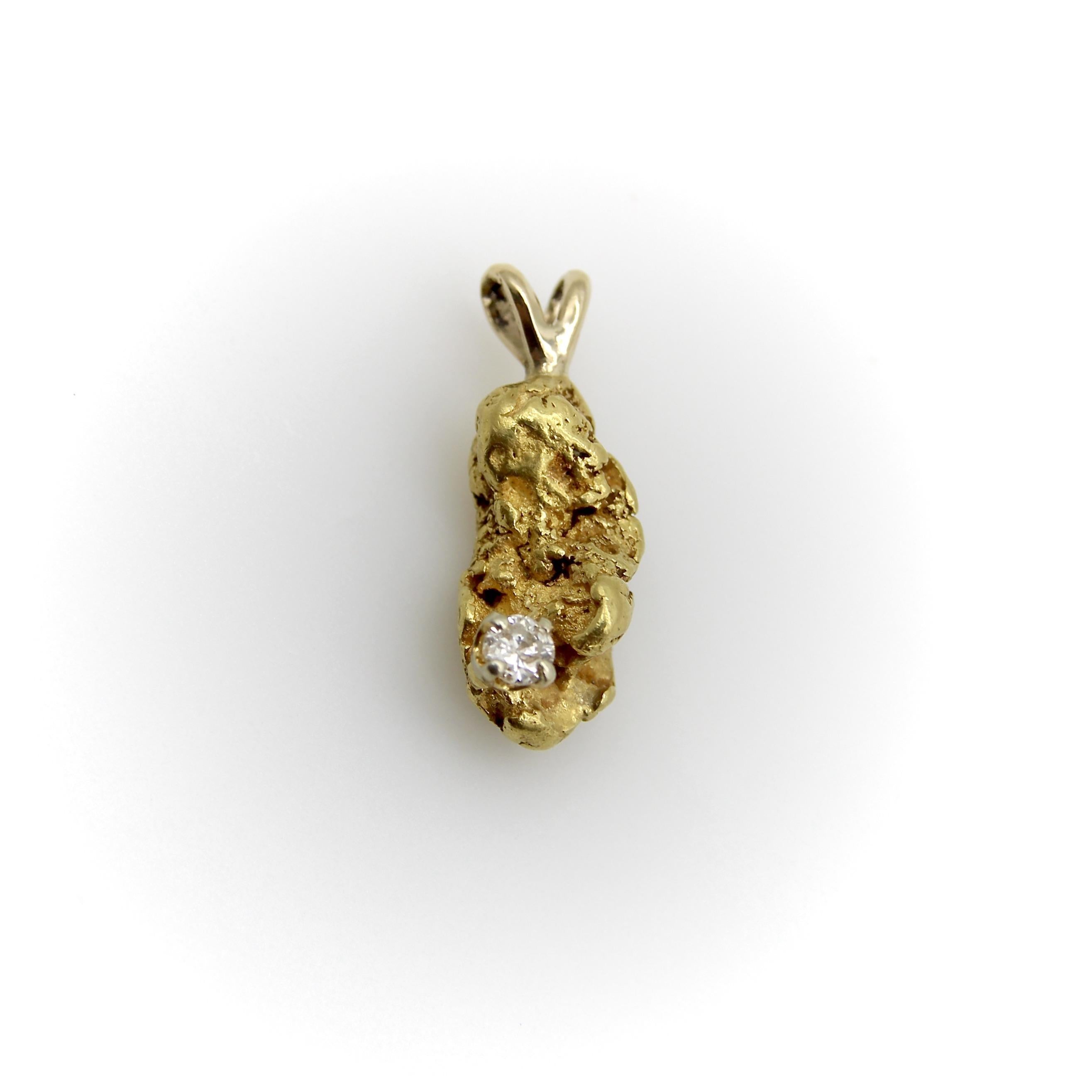 Cette magnifique breloque présente une pépite d'or 22 carats suspendue à une élégante boucle en forme de lapin. Un diamant est serti dans l'un des creux de la pépite, un placement décentré qui s'accorde parfaitement avec la forme de la pépite, comme