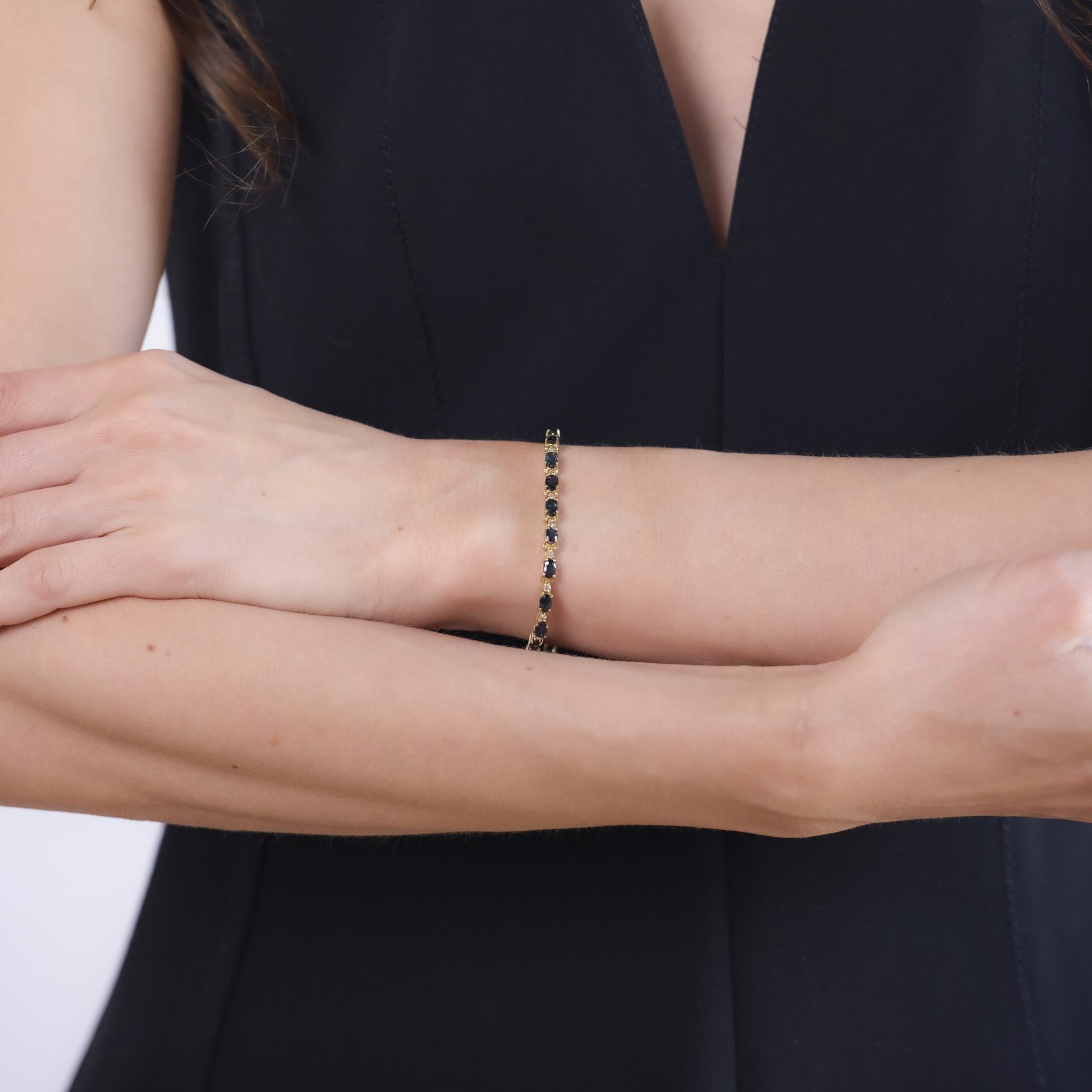 This vintage bracelet from the 1980s is crafted in 14k yellow gold and set with 23 oval cut blue sapphires totaling approximately 5.55 carats. Alternating between the sapphires are 23 round brilliant cut diamonds weighing approximately 0.50 carats,