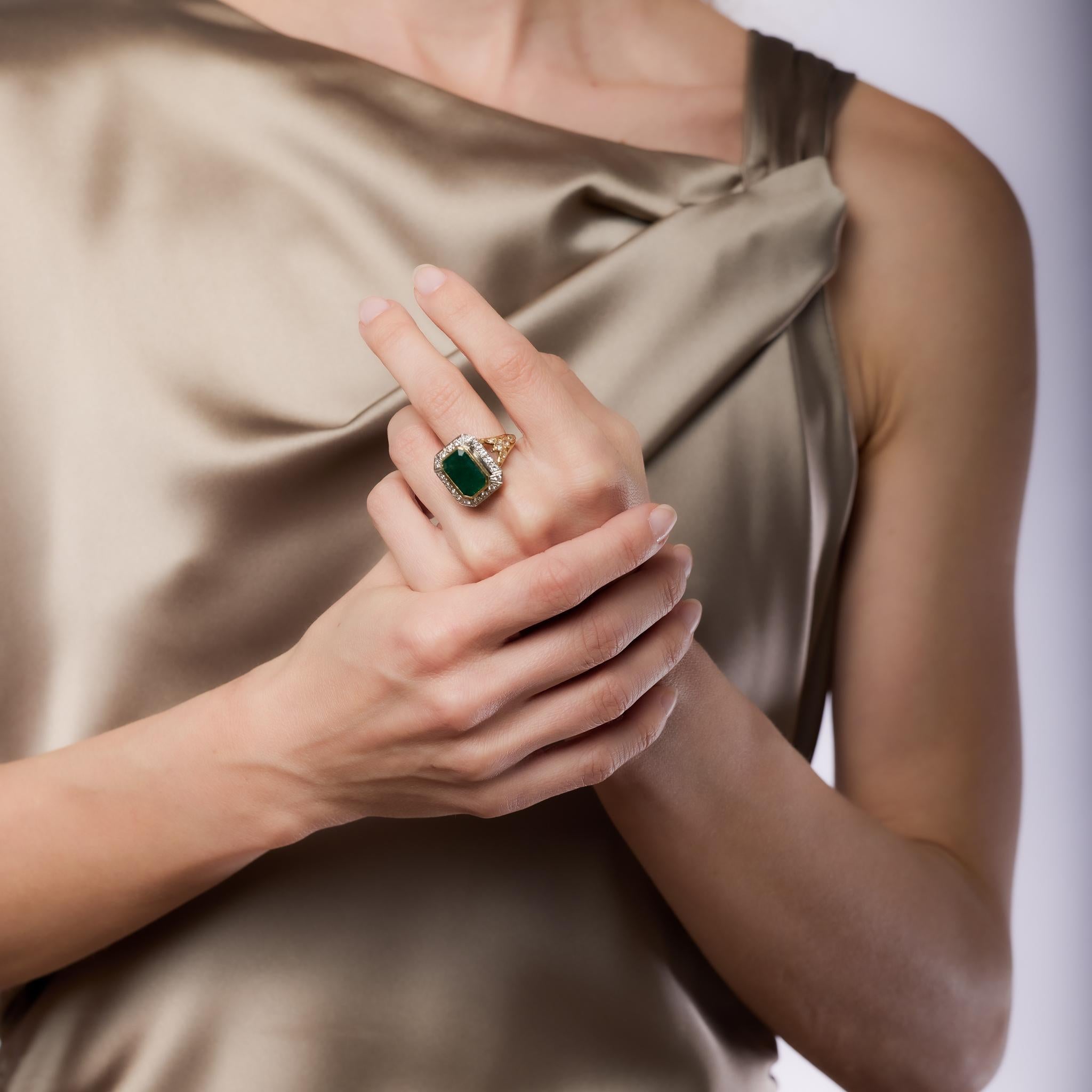 Este anillo de cóctel vintage de oro amarillo de 18 quilates y platino presenta una esmeralda de talla esmeralda certificada de 5,60 quilates con tratamiento F1, acentuada por 32 diamantes europeos antiguos, de mina antigua y talla rosa que suman
