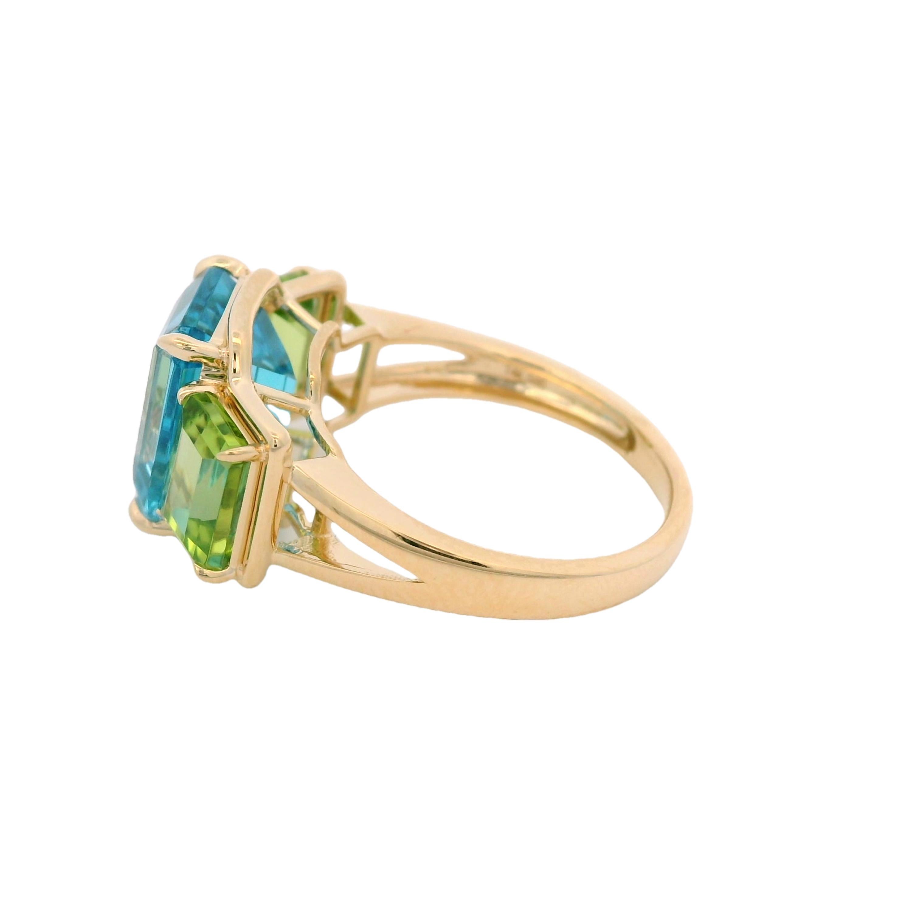 Elevate your style with this stunning 14K yellow gold ring, showcasing a captivating blend of gemstones. The centerpiece is a radiant emerald-cut Swiss Blue Topaz weighing 5.63 carats, exuding a vibrant sky-blue hue. Flanking the topaz are two