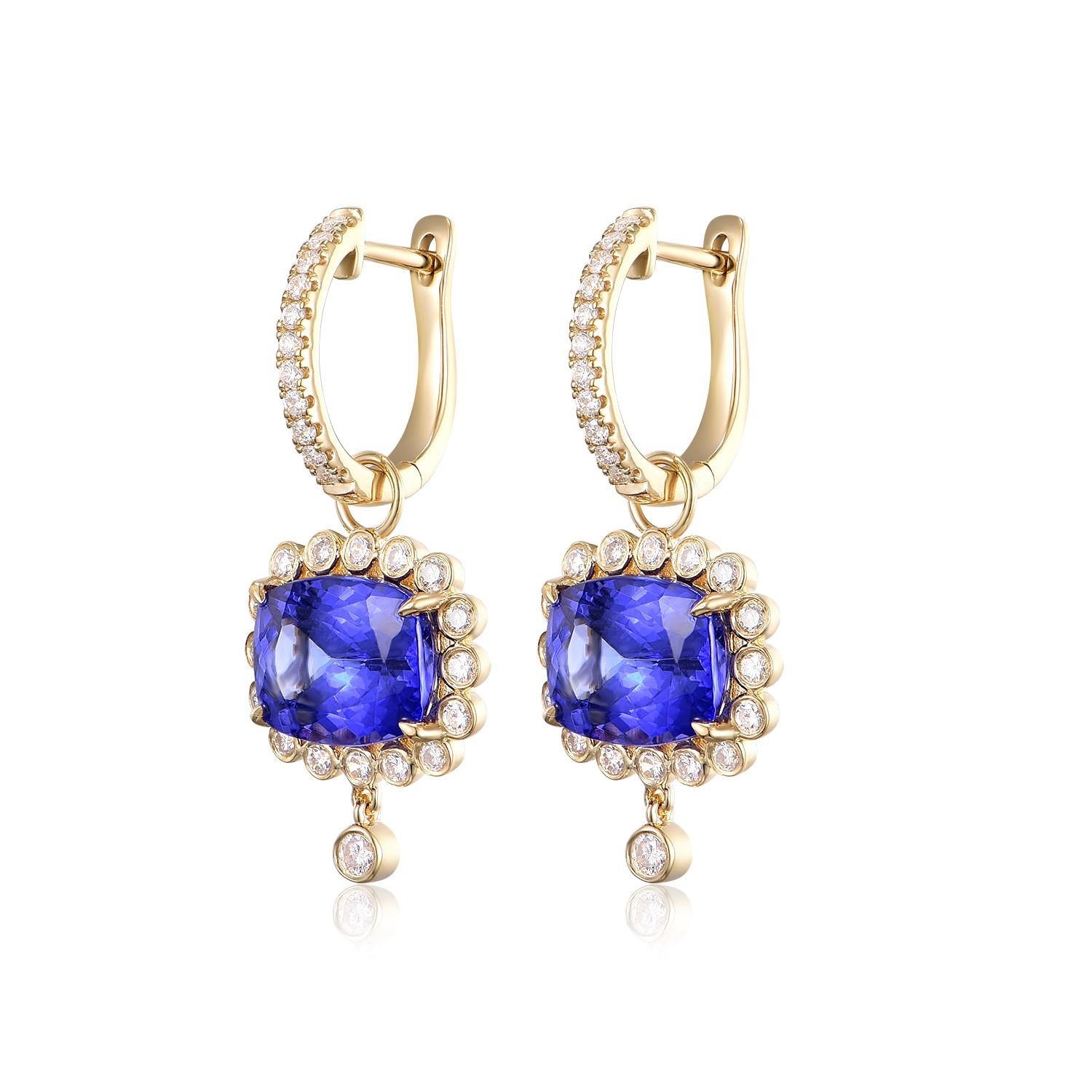 
These are resplendent 18-karat yellow gold earrings, each adorned with a central tanzanite stone totaling 5.68 carats. The tanzanites are cut into cushion shapes, their faceted surfaces revealing a deep and enthralling violet-blue hue that