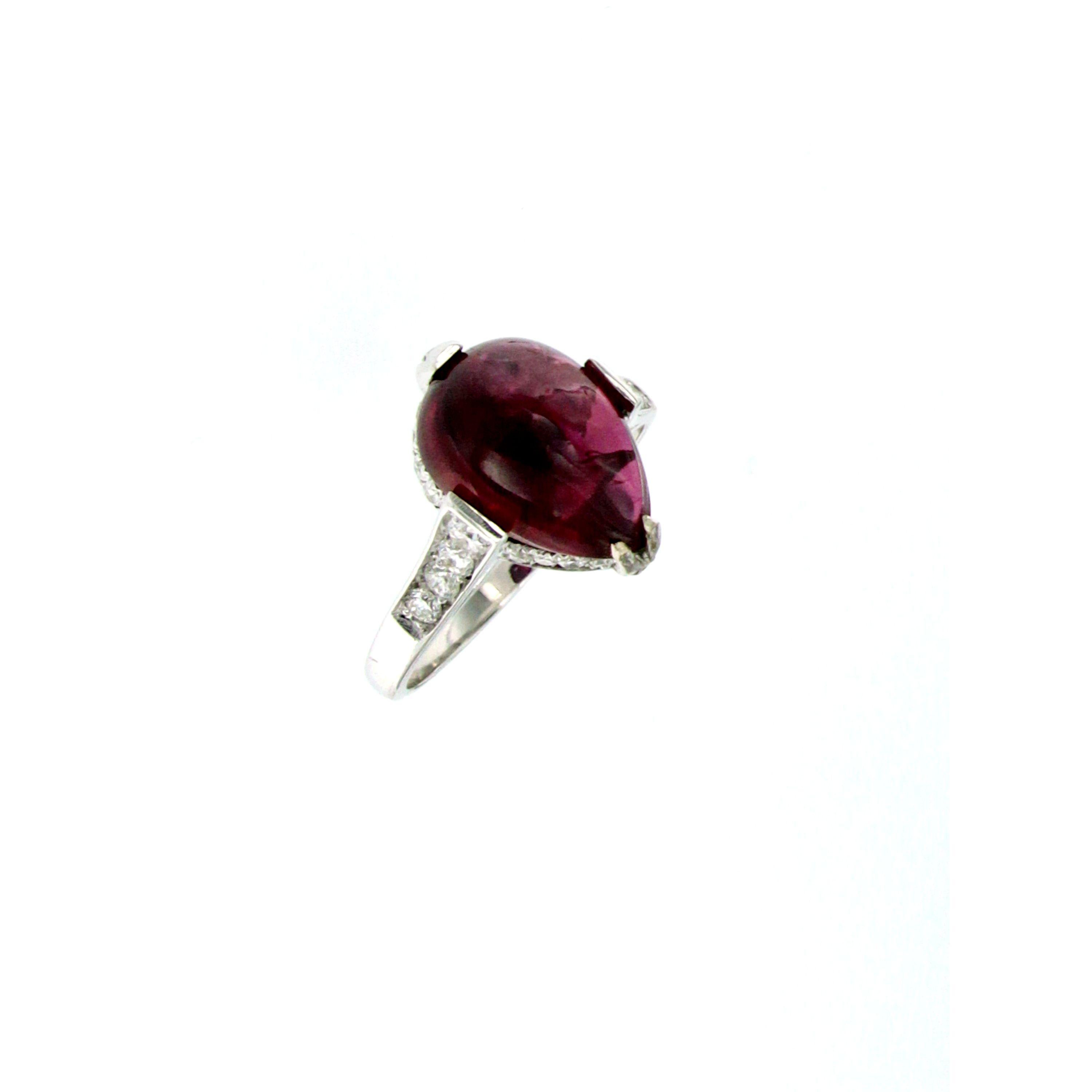 This beautiful and bright cocktail ring is set in the center with one large natural Pear Cabochon Cut Ruby with a vibrant and rich color, weight 5,89 ct. surrounded by 0,50 of colorless round brilliant cut diamonds graded G color VVS.

CONDITION: