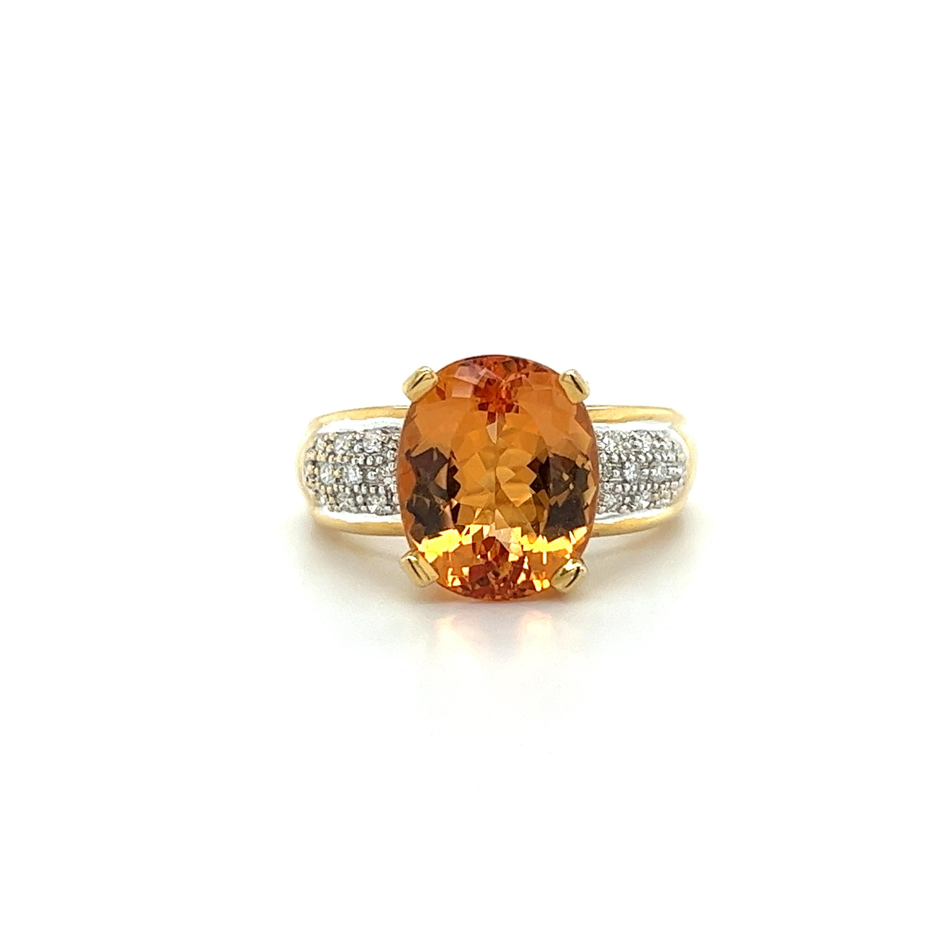 A vintage topaz and diamond ring, set in 18k solid yellow and white gold, containing a natural oval cut orange topaz. The ring contains round side diamonds with a cumulative weight of 0.30 carats. Total gram weight of the ring is 8.37 grams. A