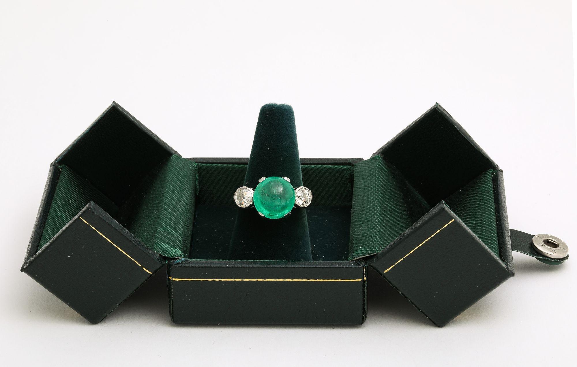 A very fine Vintage Art Deco 6 ct Certified Natural Columbian Emerald Cabochon and Diamond Platinum Engagement Ring. A stunning emerald stone is flanked by two dazzling bezel set diamonds on a unobtrusive platinum band. This ring comes with an