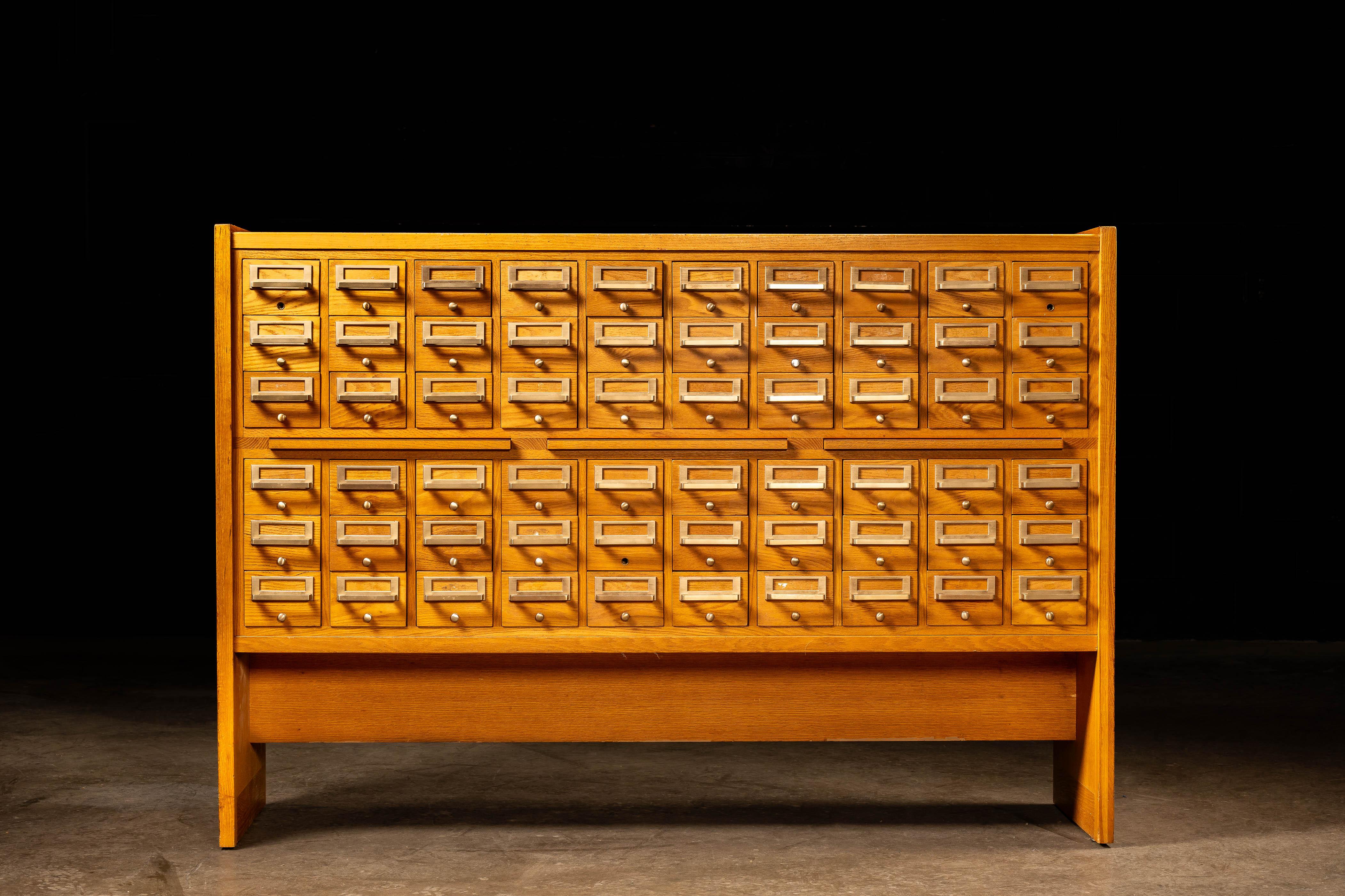 c.1960s ; (likely) Library Bureau/Remington Office Systems - Boston, MA.

Un catalogue de cartes en bois vintage, fabriqué principalement en chêne avec des ferrures en laiton d'origine.

Cette pièce comporte 60 tiroirs de taille uniforme, chacun