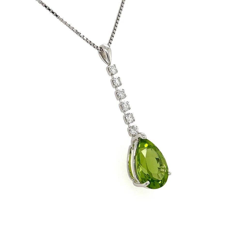 Simply Beautiful! Elegant and finely detailed Platinum Drop Pendant Necklace. Featuring a 6.06 Carat Vibrant Pear shaped Peridot., suspending from 6 RBC Diamonds, weighing approx. 0.51tcw. On a 16” long Gold chain. The necklace is in excellent