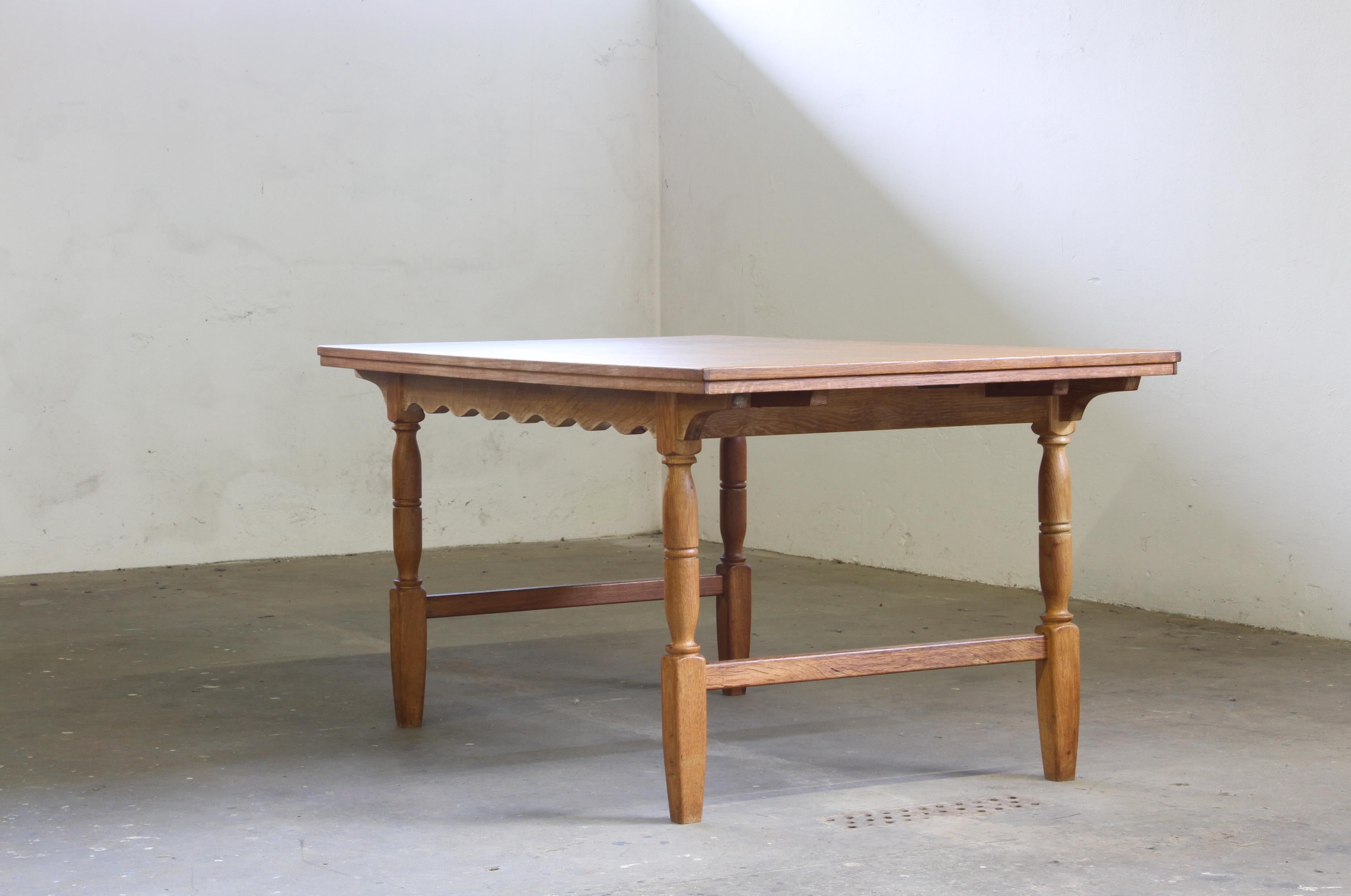 This vintage oak dining table by Axel Ö Röck and produced by Otterup Manufactor, perfectly embodies Nordic Danish craftsmanship, combining refined detailing with a bold sculptural presence. The turned legs and gently scalloped apron lend the table a
