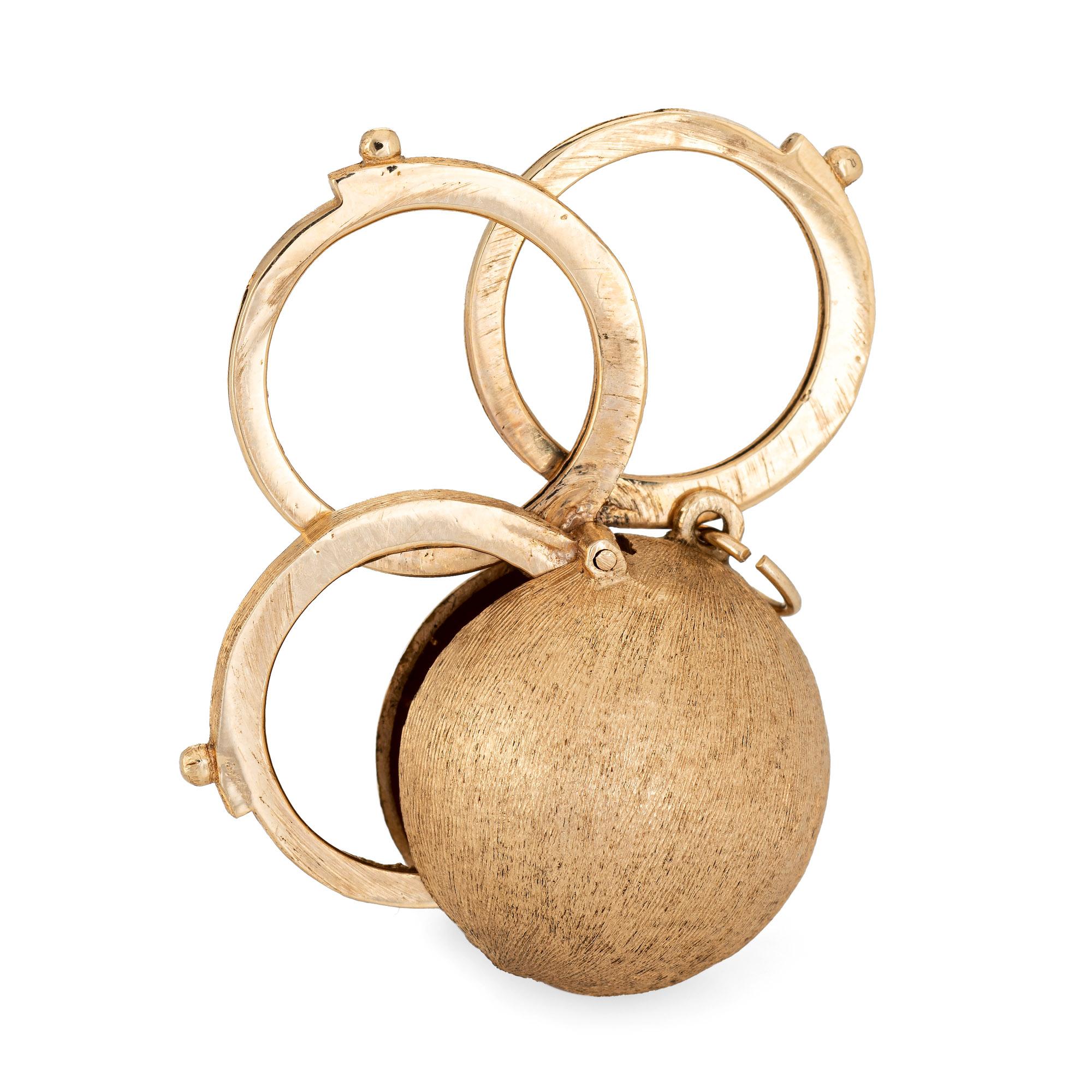 Finely detailed vintage folding picture charm (circa 1960s) crafted in 14 karat yellow gold. 

The orb features three picture frames that expand and retract flush into the orb in one fluid movement. A total of three picture frames are located within
