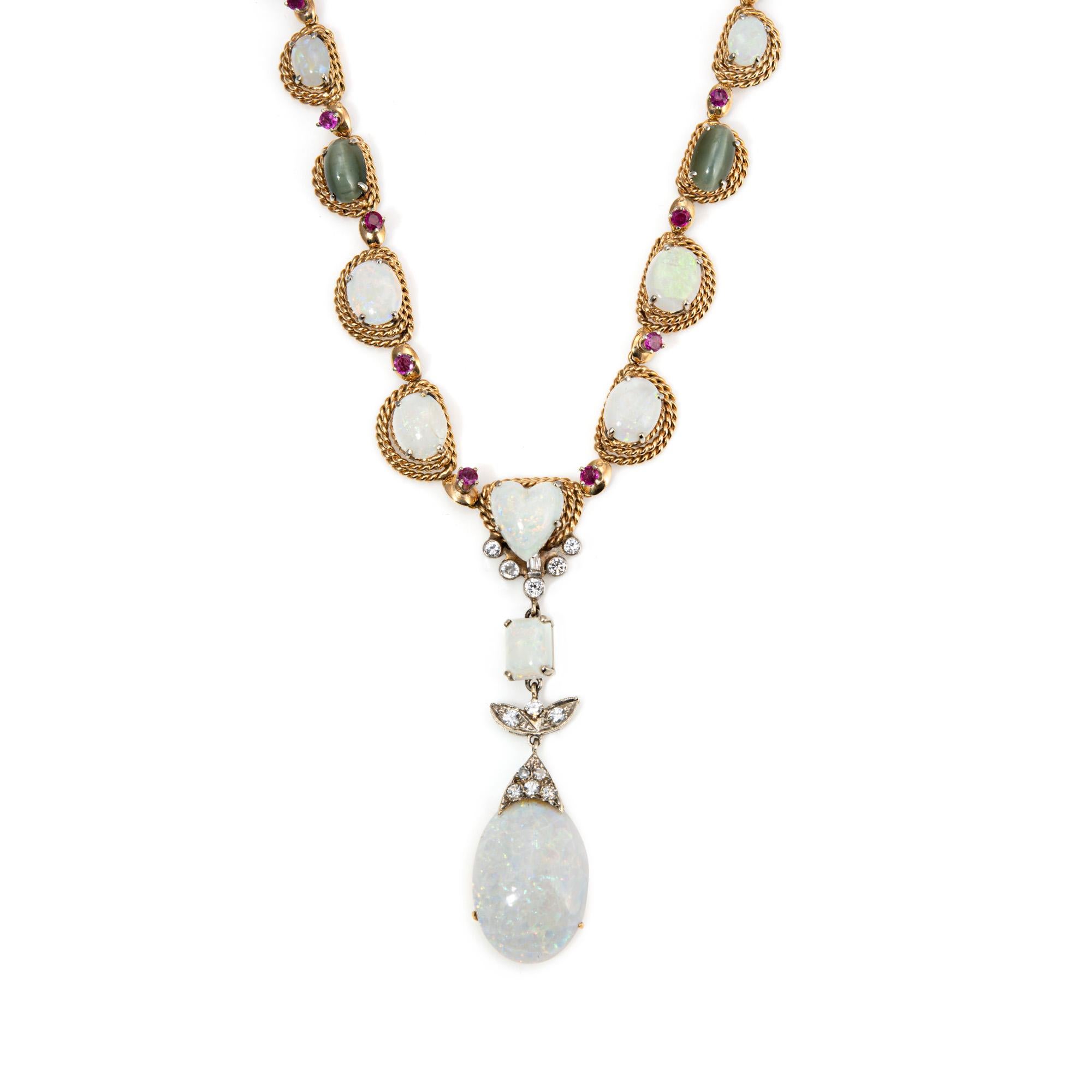 Stylish and finely detailed vintage gemstone drop necklace crafted in 14 karat yellow gold (circa 1960s). 

Opals, rubies, star sapphires and cat's eye is set into the necklace. The larger opal drop measures 23mm x 17mm. Diamonds total an estimated
