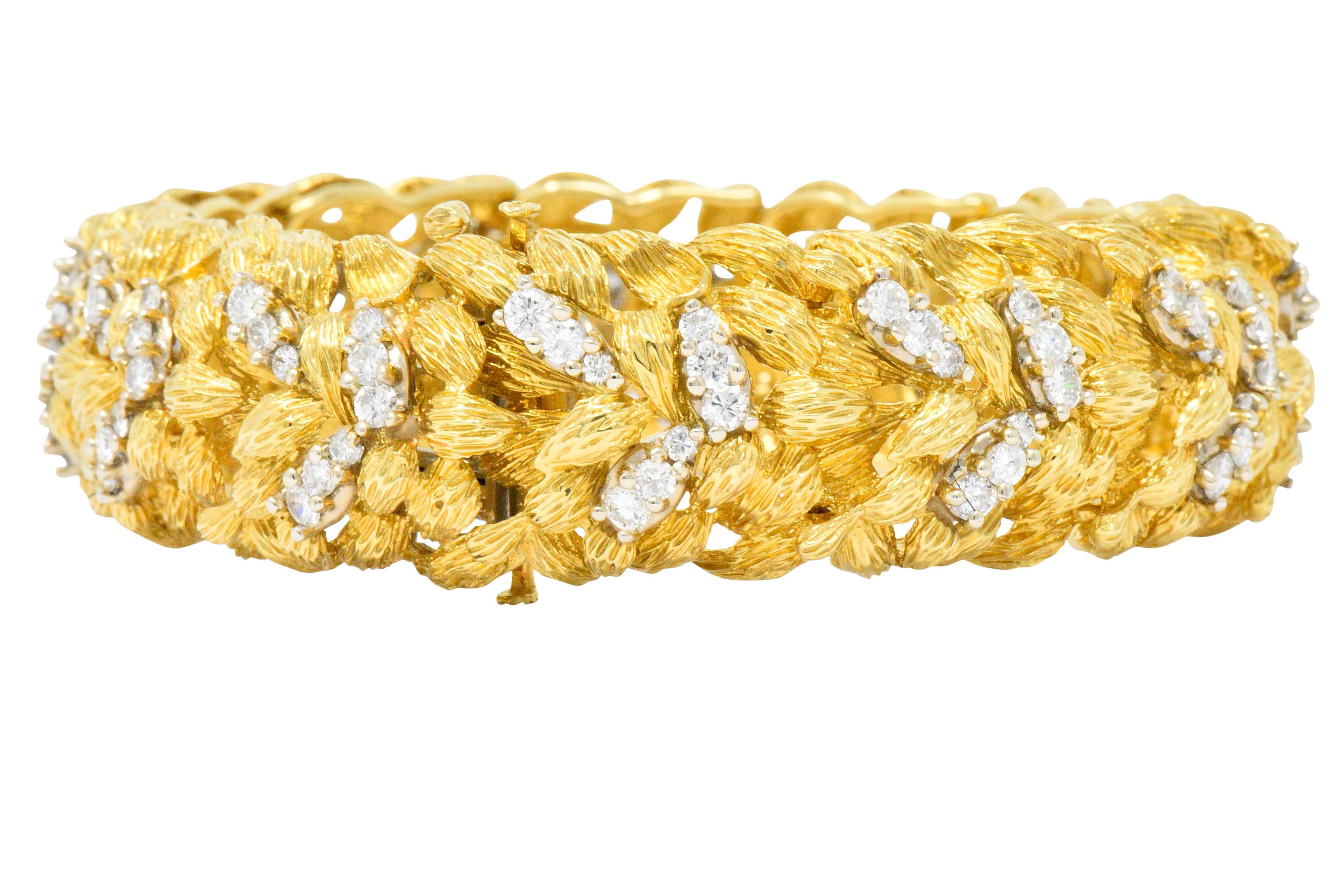 Designed as flowing and over-lapping abstract textured gold leaves

Accented with round brilliant cut diamonds, weighing approximately 6.24 carats total, F/G color and VS to SI1 clarity

With a concealed clasp and fold-over safety, and