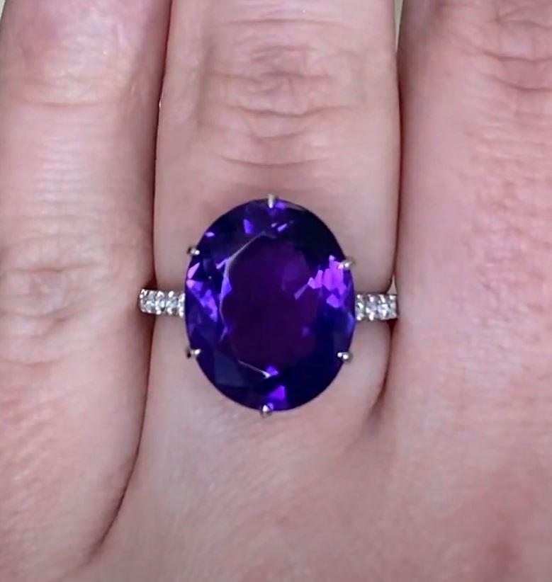 This exquisite vintage engagement ring showcases a stunning approx. 6.4-carats oval-cut amethyst as its centerpiece, securely prong-set in luxurious platinum. The deep, regal hue of the amethyst is beautifully complemented by its expertly faceted