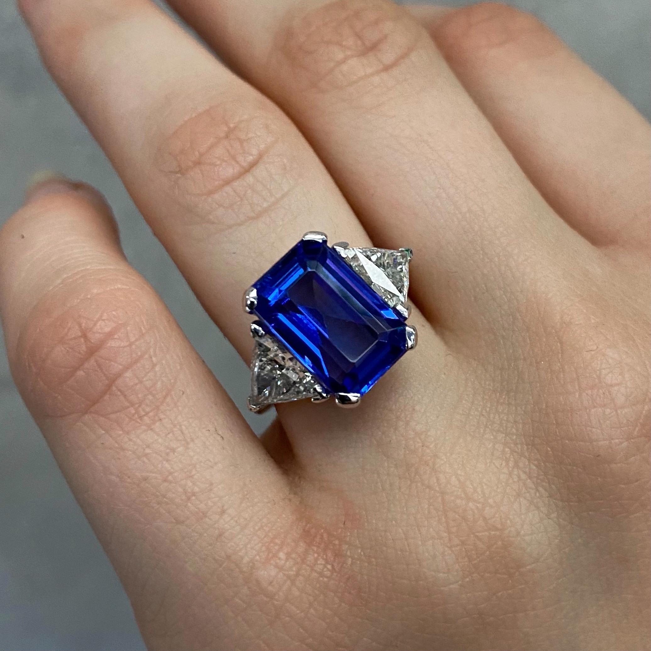 Vintage Tanzanite and Diamond Cocktail Ring in 14kt White Gold, Portugal, 1990s. This breathtaking jewel features a certified an intense slightly purplish blue 6.49-carat emerald-cut tanzanite claw-set to the centre, flanked to each side by a
