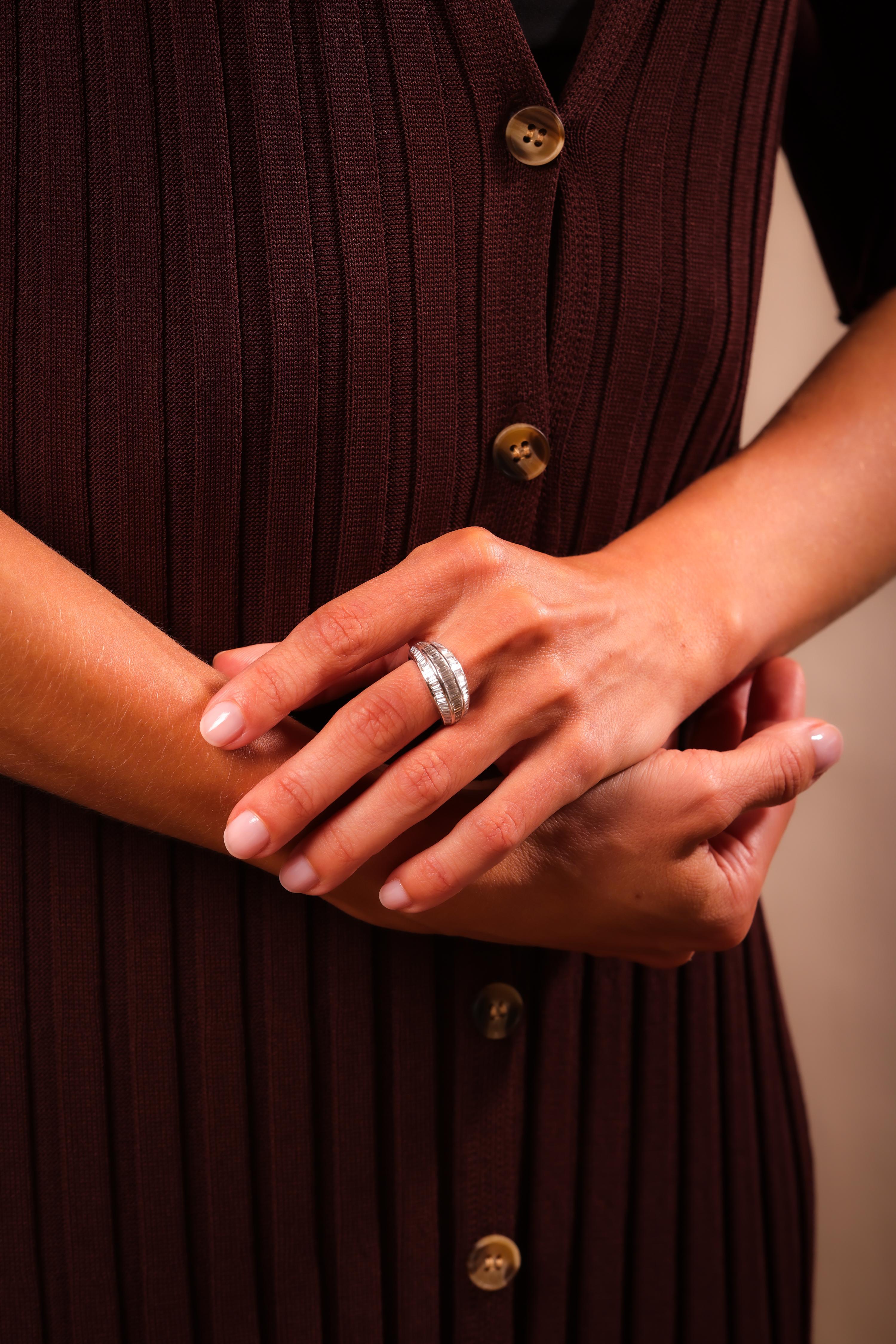 Center Stone: 105 Baguette Cut Diamonds
Weight: 6.5 Carat
Color: F-G
Clarity: VS2
Metal: 18K White Gold
Era: Vintage
Circa: 1980s
Hallmarks: Purity Marks
Size: 5.5 and can be resized
Gram weight: 7.9

This stunning vintage ring from the 1980s is
