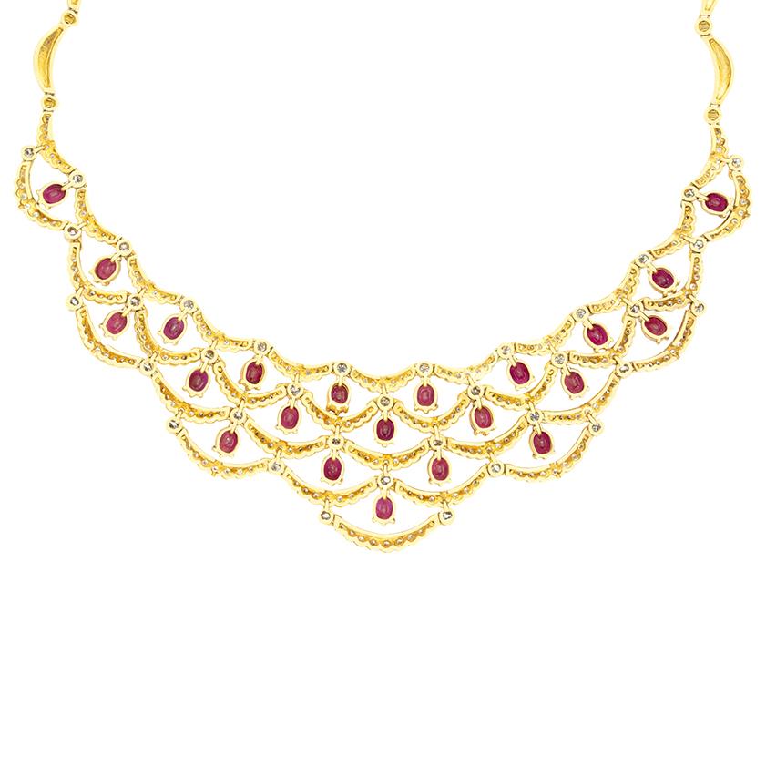 A breathtaking display of vintage elegance, this exquisite ruby and diamond necklace cascades in a delicate draped design. A total of 6.60 carats of vivid, oval cut rubies sits on display, each weighing 0.30 carat each suspended between cascading