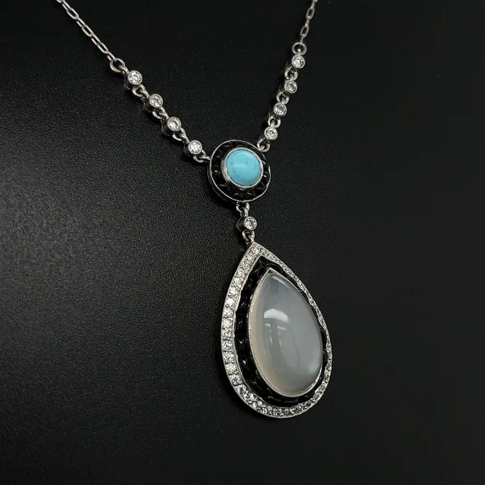 Simply Beautiful! Elegant and finely detailed Platinum Moonstone, Turquoise, Diamond and Onyx Drop Pendant Necklace. Featuring a 6.62 Carat Pear shaped Moonstone, surrounded by 48 OEC Diamonds, approx. 0.60tcw and 28 Onyx, approx. 0.50tcw, suspended