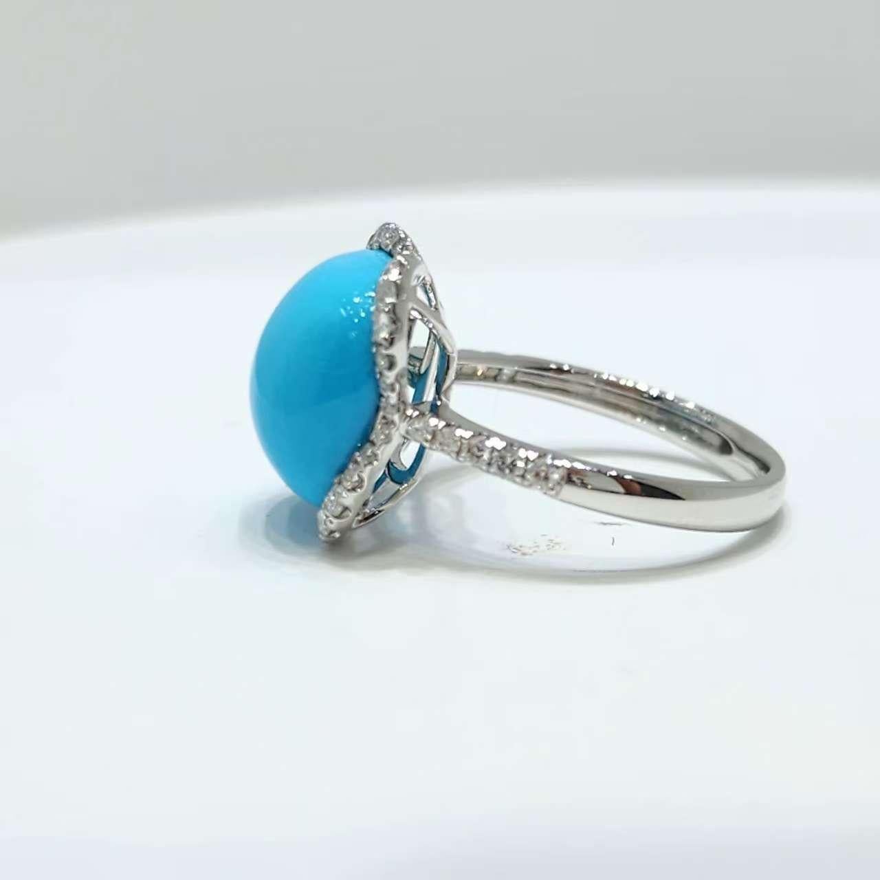 Dieser exquisite Ring ist aus massivem 18-karätigem Weißgold gefertigt und zeigt in der Mitte einen atemberaubenden 6,9-karätigen Dornröschen-Türkis. Der Dornröschen-Türkis ist bekannt für seine reine, rotkehlchenblaue Farbe ohne sichtbare Matrix