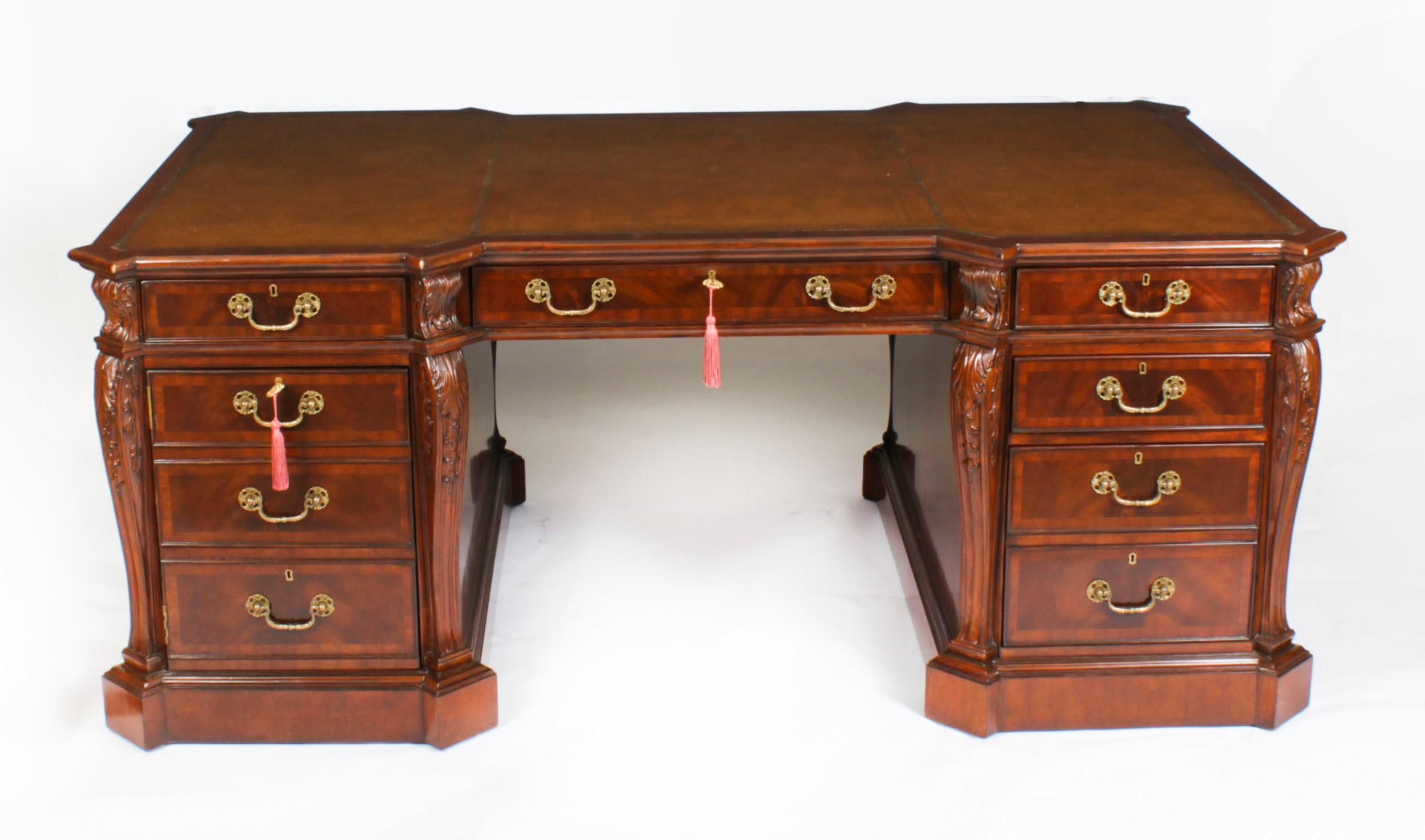 An exquisite Vintage  flame mahogany partners pedestal desk that dates from the late 20th Century.

This desk has been accomplished in the Georgian manner and is beautifully crafted from flame mahogany with satinwood crossbanded decoration.

The