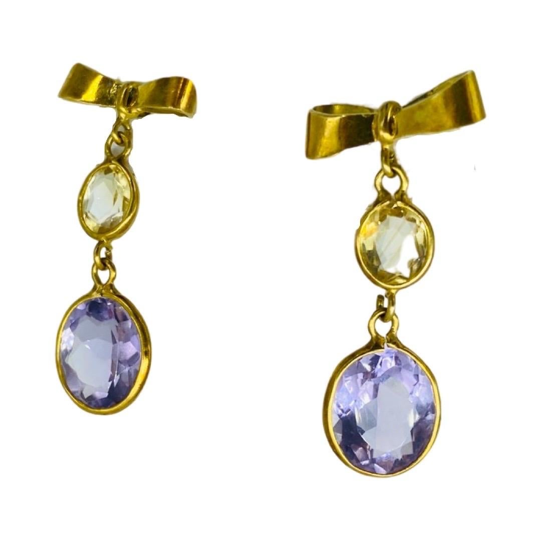 Amethyst and Citrine Gemstone Bow Tie Dangle Earrings 18k Gold. Impressive design and sturdy earrings featuring a secure screw back. The amethyst measures 11x9x5.46mm for a total of 2.86 carat. The citrine measures 7x5x3.30mm for a total of 0.61