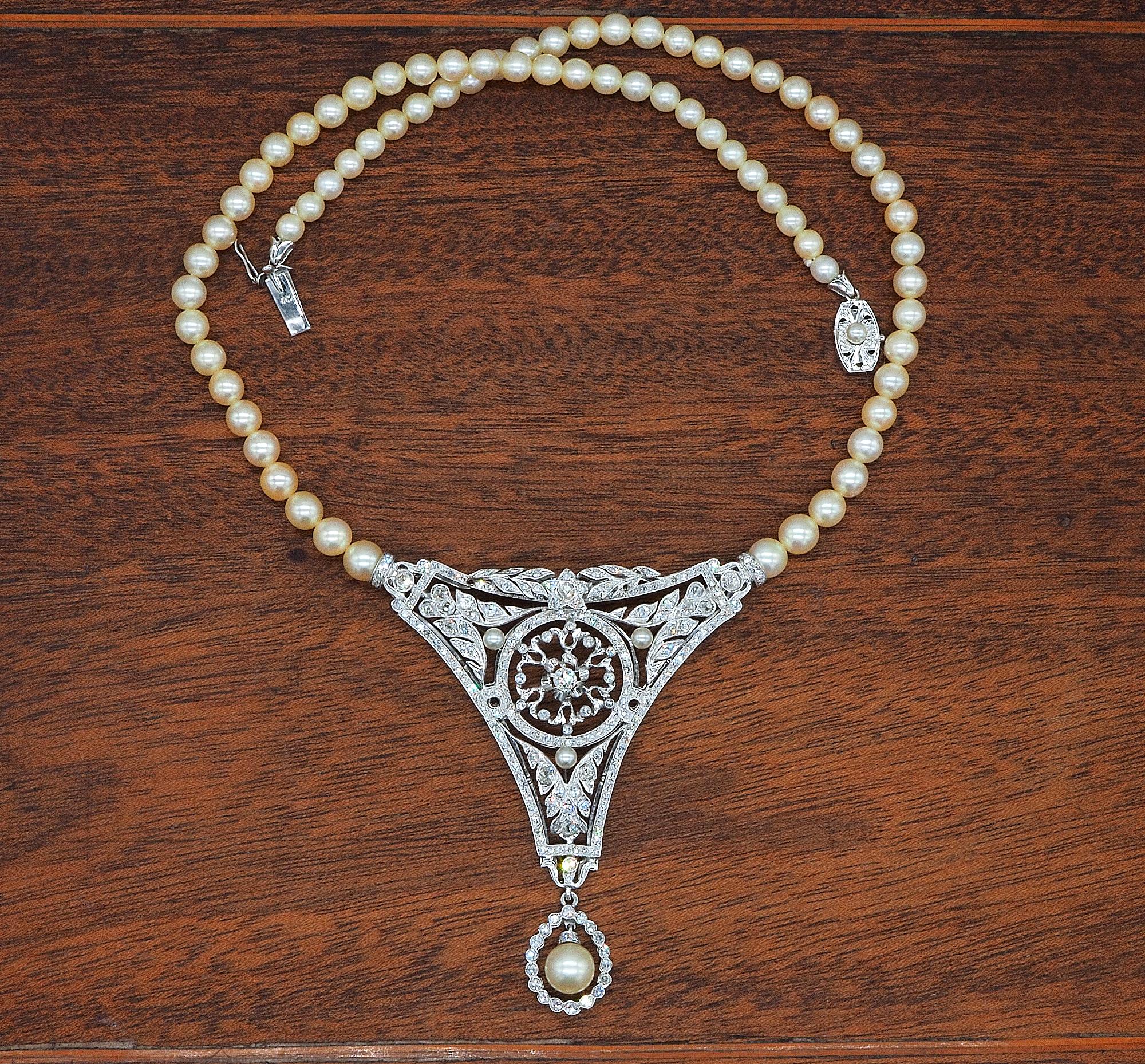This enchanting vintage necklace is 1935 circa
Composed by a single strand of salt water cultured pearls ranging in sizes from 5 to 7 mm. - connected to an impressive large panel surmounted by Diamonds with suspending pearl as finial
Artful hand