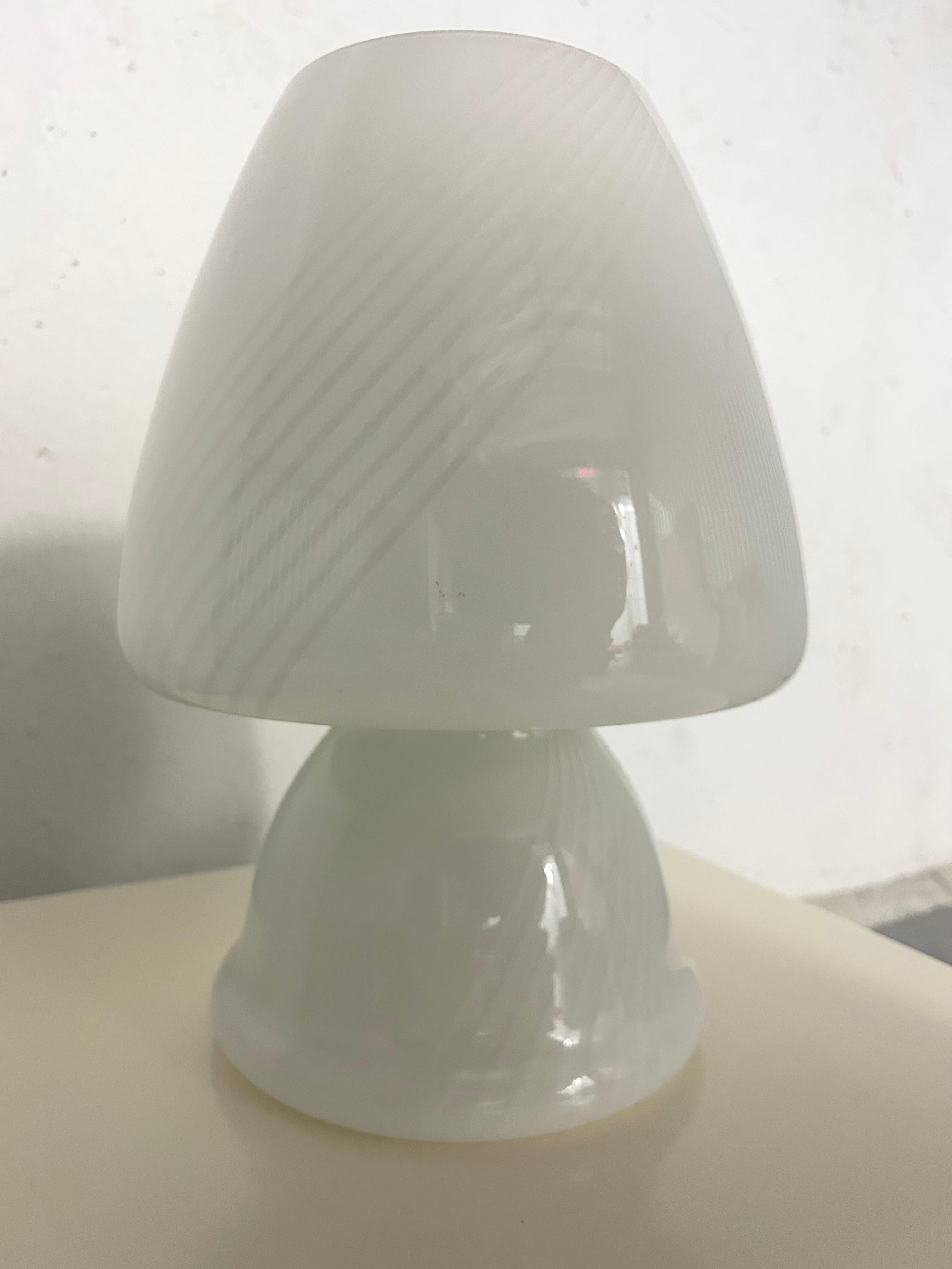 Lampe champignon en verre soufflé vintage des années 1970 avec un design en forme de tourbillon. Non marqué - pas d'information sur le fabricant ou l'origine. Probablement de Murano, Italie. Pas d'éclats ni de rayures. La prise américaine est