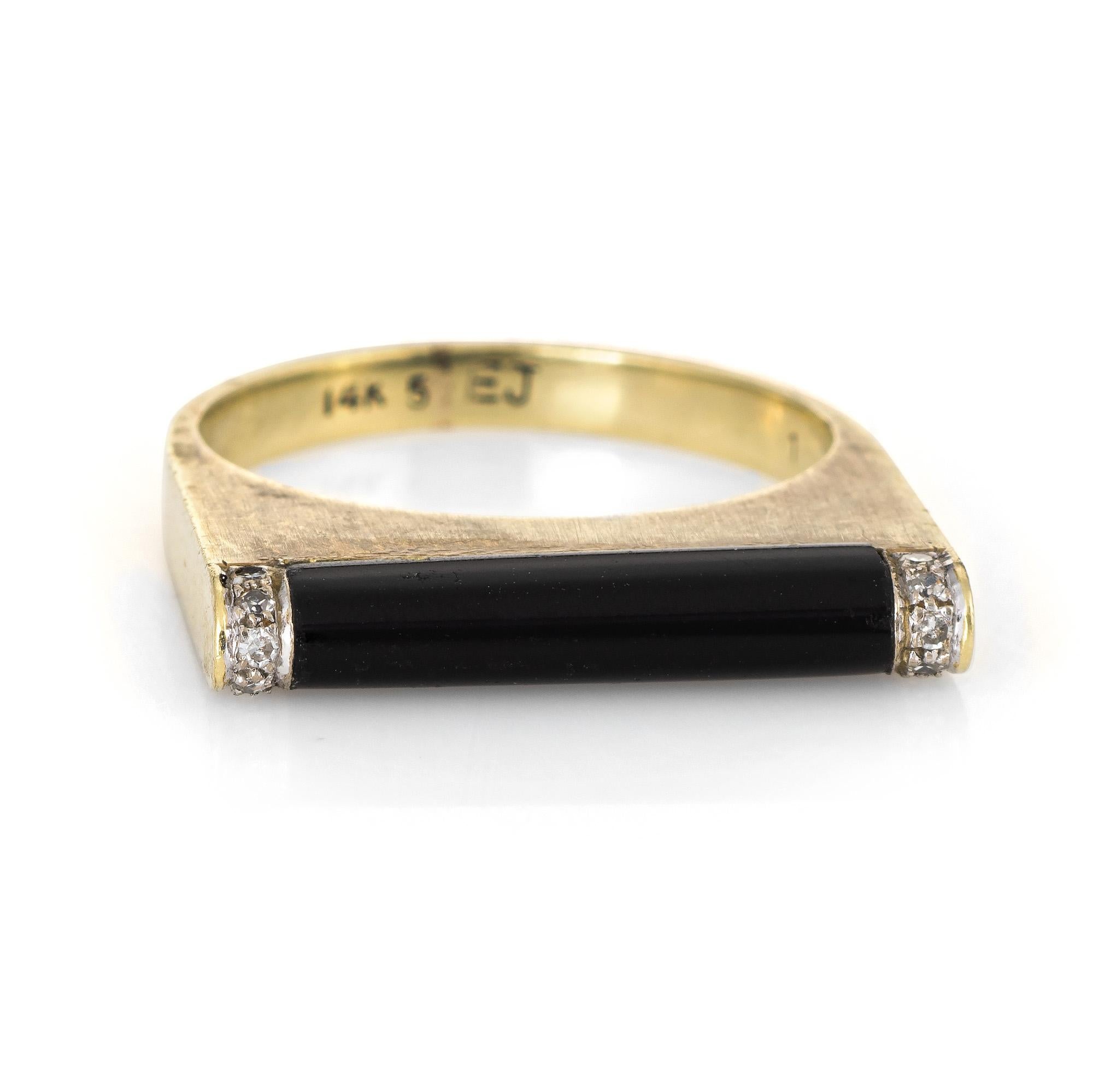 Stylish vintage black onyx & diamond bar ring (circa 1970s) crafted in 14 karat yellow gold. 

Black onyx measures 16mm x 3mm, accented with an estimated 0.05 carats of diamonds (estimated at I-J color and SI1-2 clarity). The onyx is in excellent