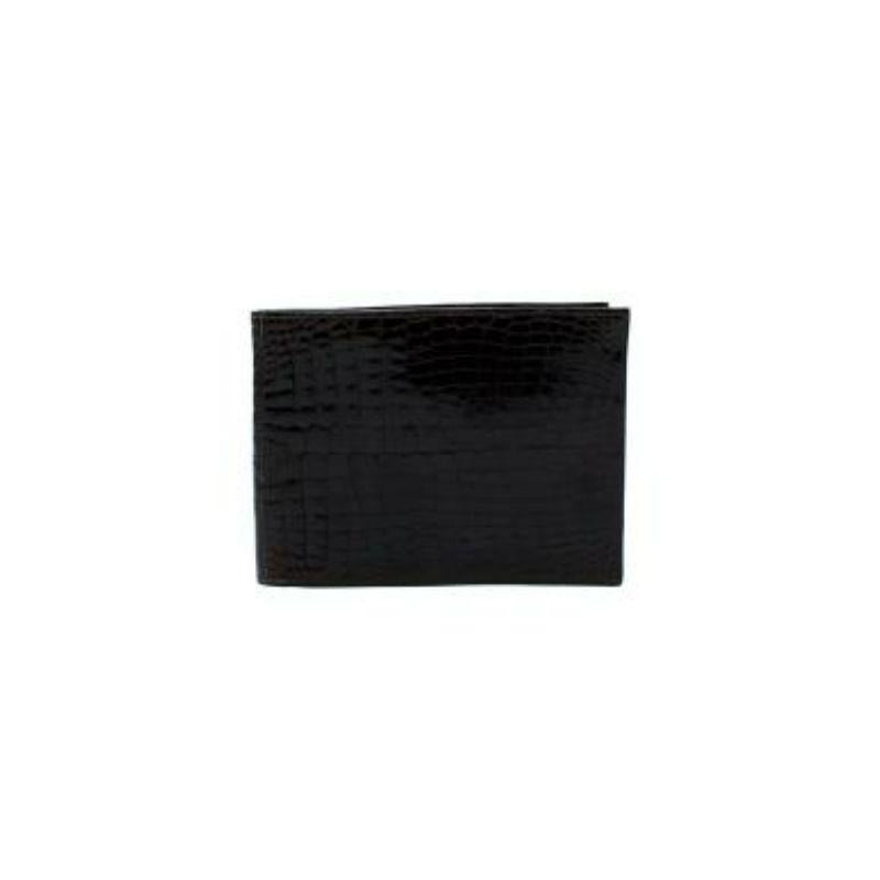 Hermes Ebene Lisse Crocodile Bi-Fold Wallet
 
 
 
 - Shiny Ebene Lisse Crocodile body 
 
 - Rectangular shape 
 
 - Clear panel pouches
 
 - Two card slip pockets 
 
 - Fully lined with leather
 
 - Date stamp C in a circle- 1973
 
 
 
 Materials:
