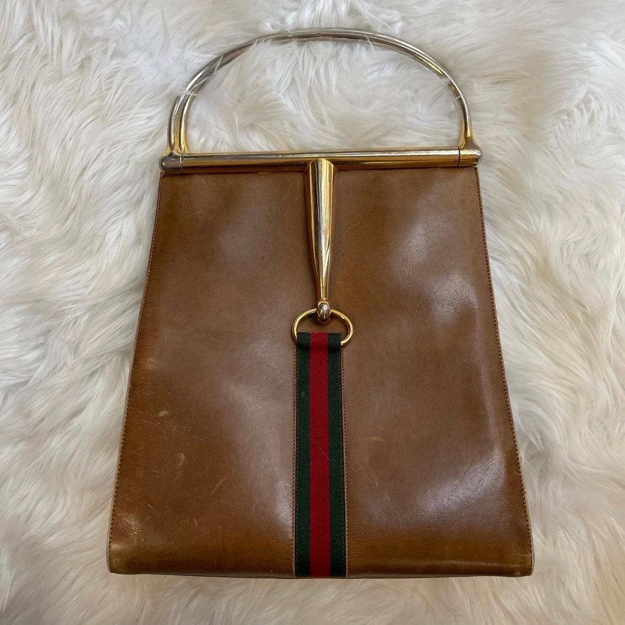 Sehr seltene Vintage Gucci Tote Bag aus den 70er Jahren. 

Ein solches Exemplar befindet sich derzeit im Tresor von Gucci! 

Gefertigt aus braunem Leder mit roten und grünen Streifen auf der Vorder- und Rückseite. Oben offen mit goldenen
